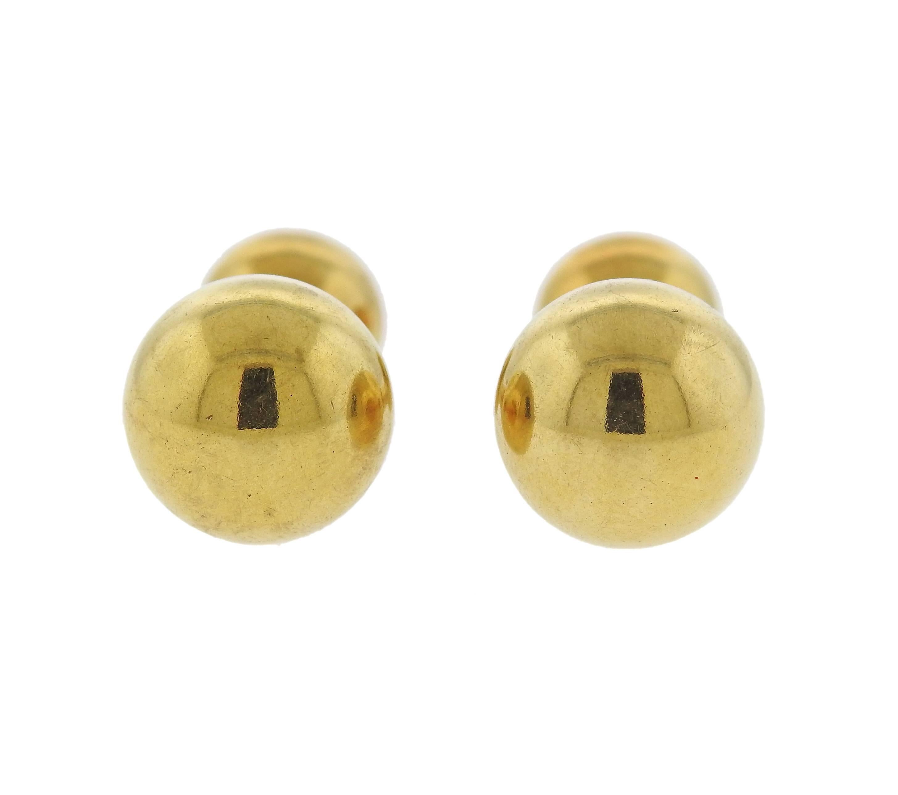 Pair of 18k yellow gold dumbbell cufflinks, crafted by Cartier. Cufflink top is 13mm in diameter, back - 9.5mm. Weight - 11.1 grams. Marked: Cartier, 18k. 