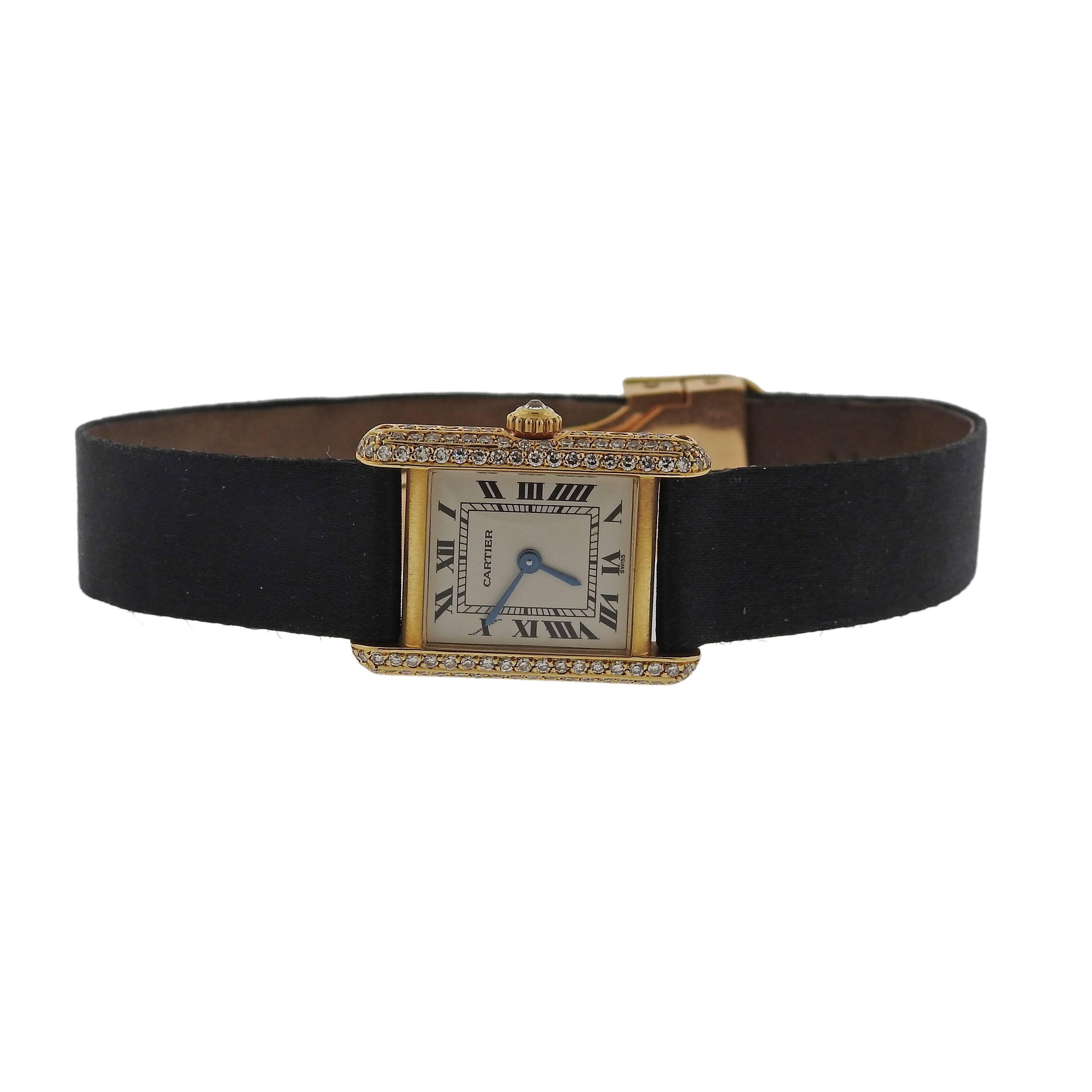 Cartier lady's Tank classic watch,  featuring 18k yellow gold case, decorated with diamonds. Satin black leather band with 18k gold deployment buckle will fit wrist size 6 3/4. Case size - 18mm excl crown x 25mm. Quartz movement. 