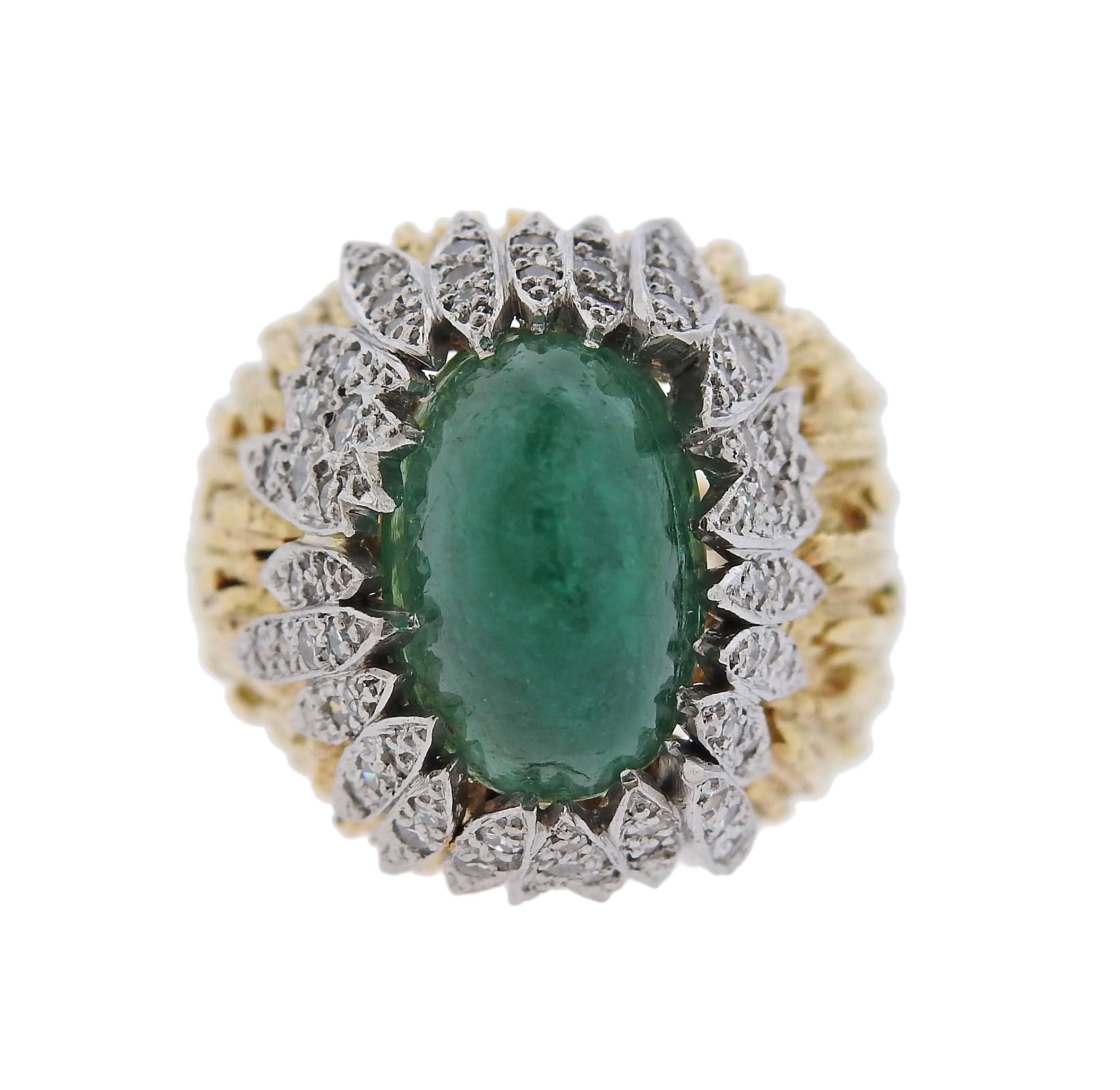An 18k gold ring, crafted by Andrew Grima, set with an approximately 6ct emerald cabochon, surrounded with 0.36ctw in diamonds. Ring size - 5, ring top is 19mm x 20mm, sits approx. 19mm from the top of the finger. Marked Grima. Weight of the piece -