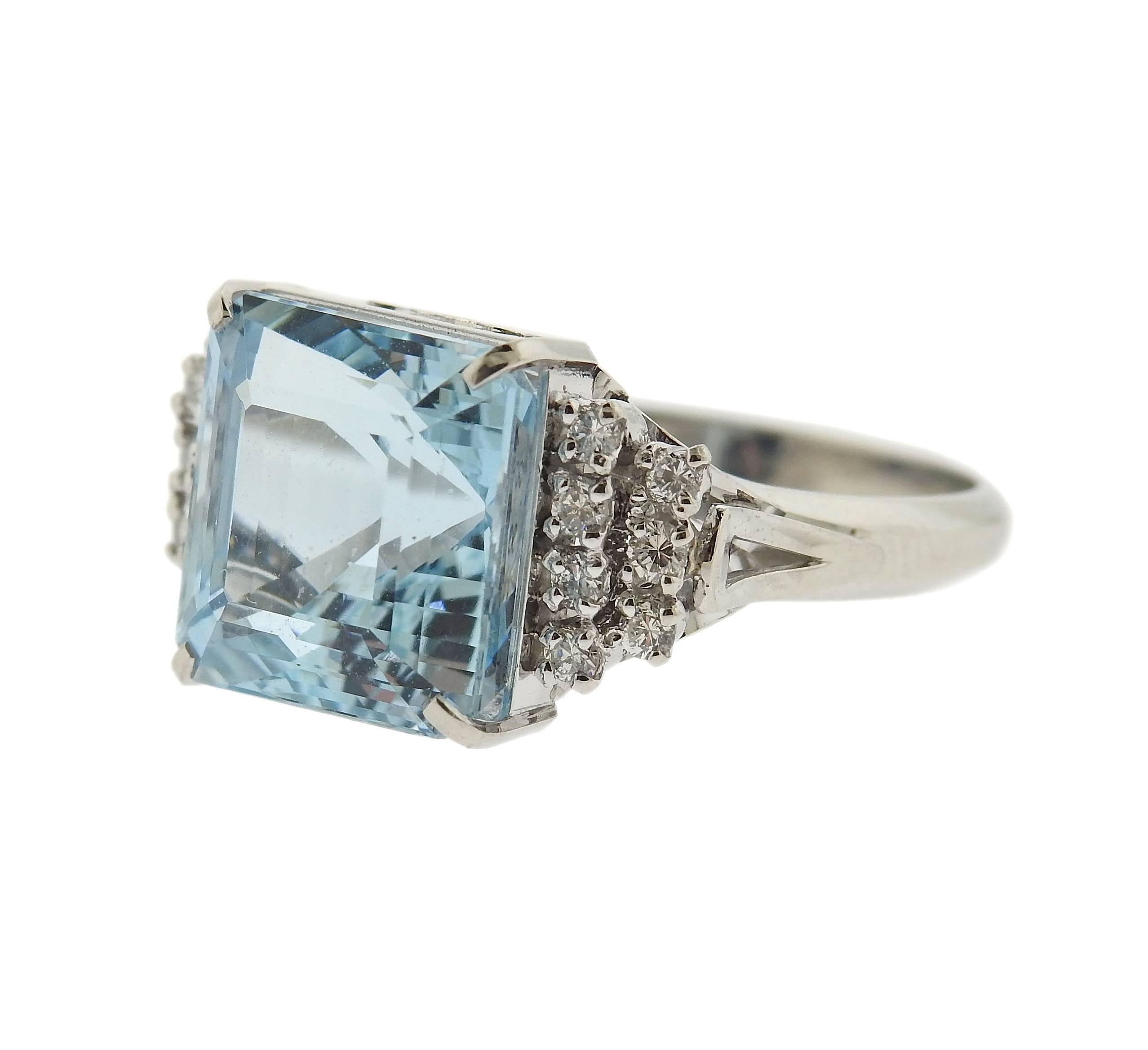 Platinum classic ring, set with  a 7.02ct aquamarine gemstone, surrounded with 0.27ctw in diamonds. Ring is a size 6 1/2, ring top is 11mm x 18mm. Marked: Pt900, 702, D027. Weight of the piece - 7.8 grams. 