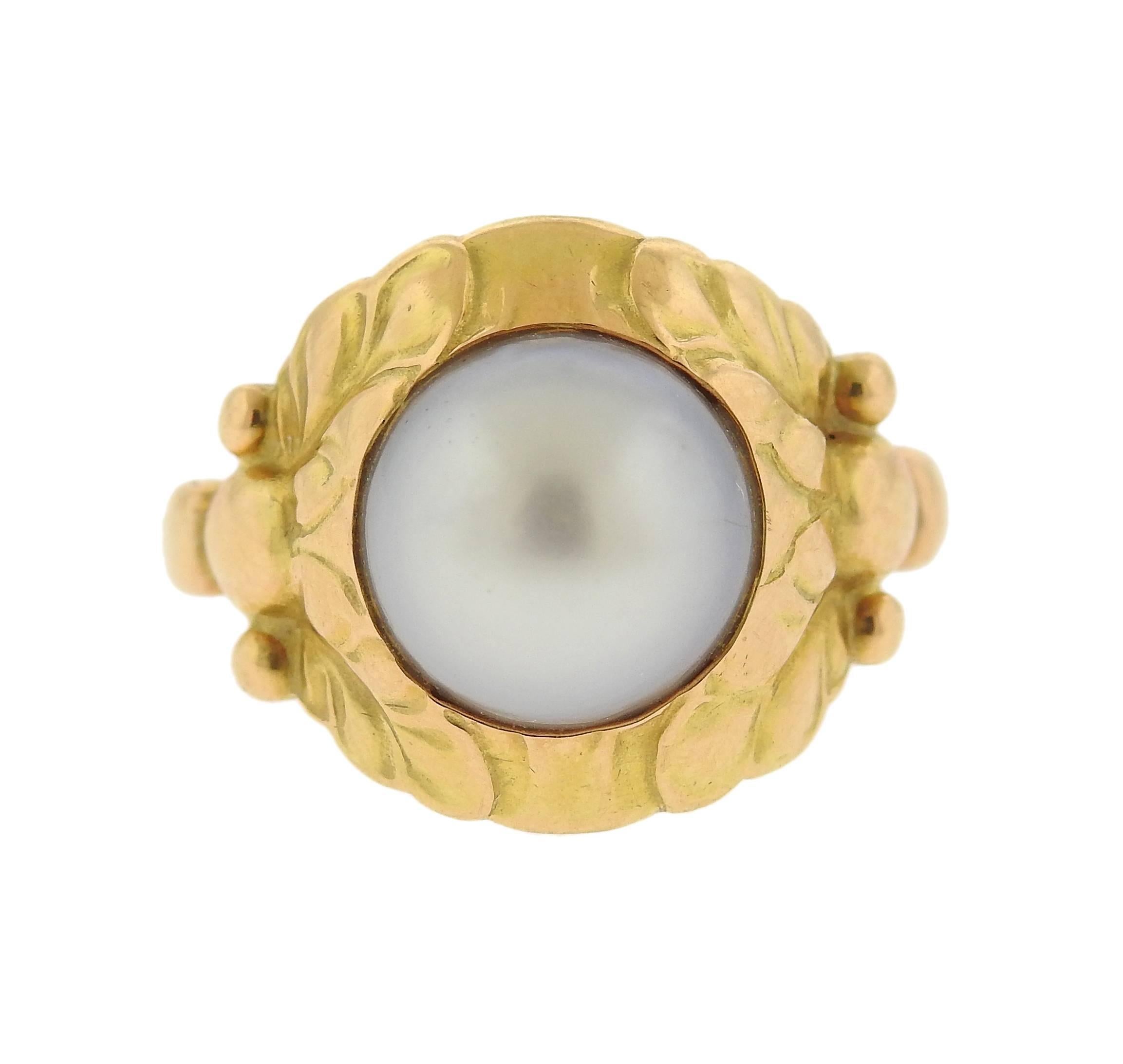 An 18k yellow gold ring, crafted by Georg Jensen, set with a 9.8mm pearl. Ring size - 7 1/4, ring top is 15mm. Marked: 76 18k, 111 B, Jensen hallmark. Weight of the piece - 4.3 grams.