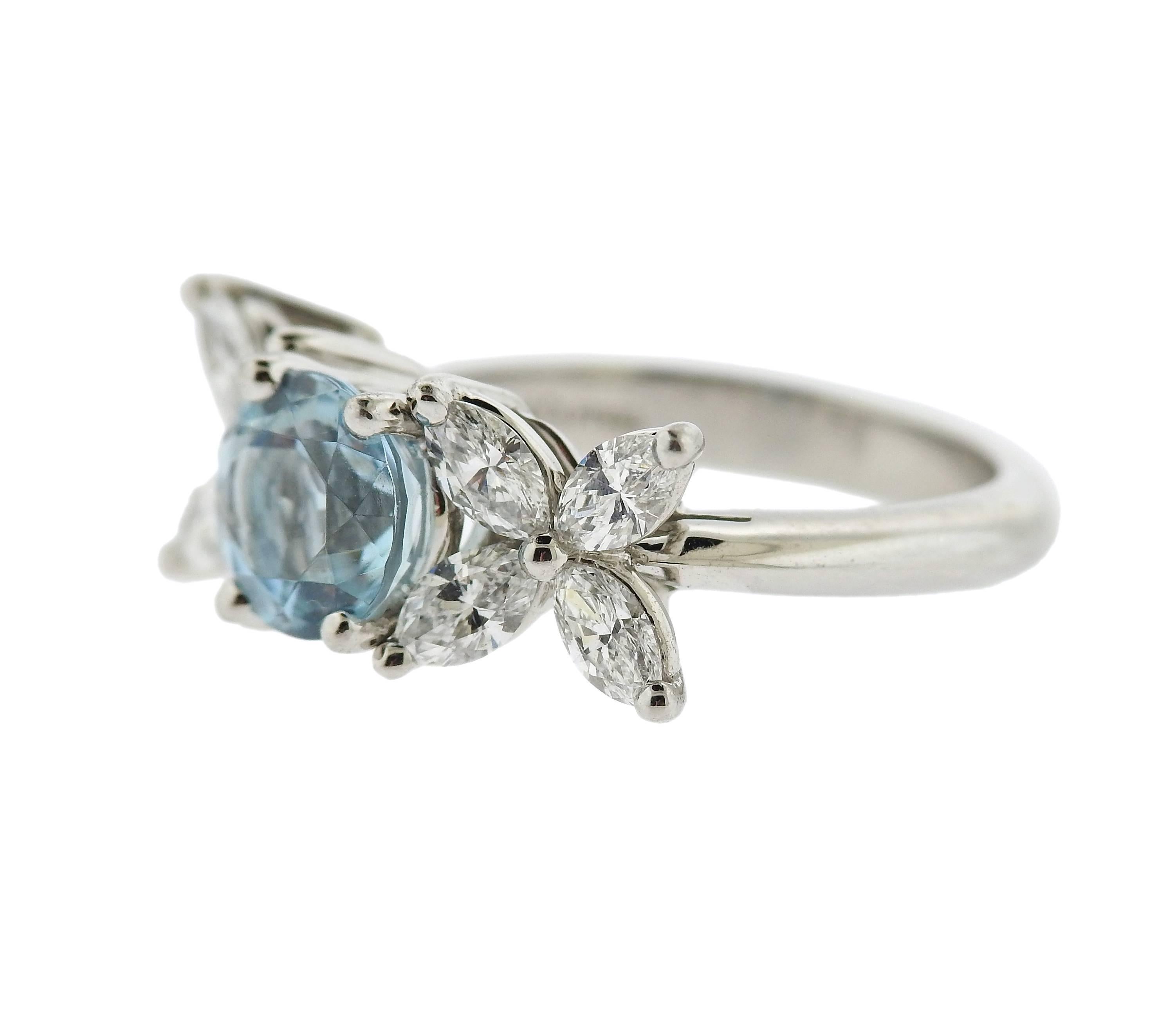 Delicate platinum ring, crafted by Tiffany & Co for Victoria collection, set with a round aquamarine in the center - approx. 1.20ct, surrounded with approx. 0.80ctw in marquis diamonds. Ring size 5 3/4, ring top is 8mm x 20mm. Marked: Tiffany