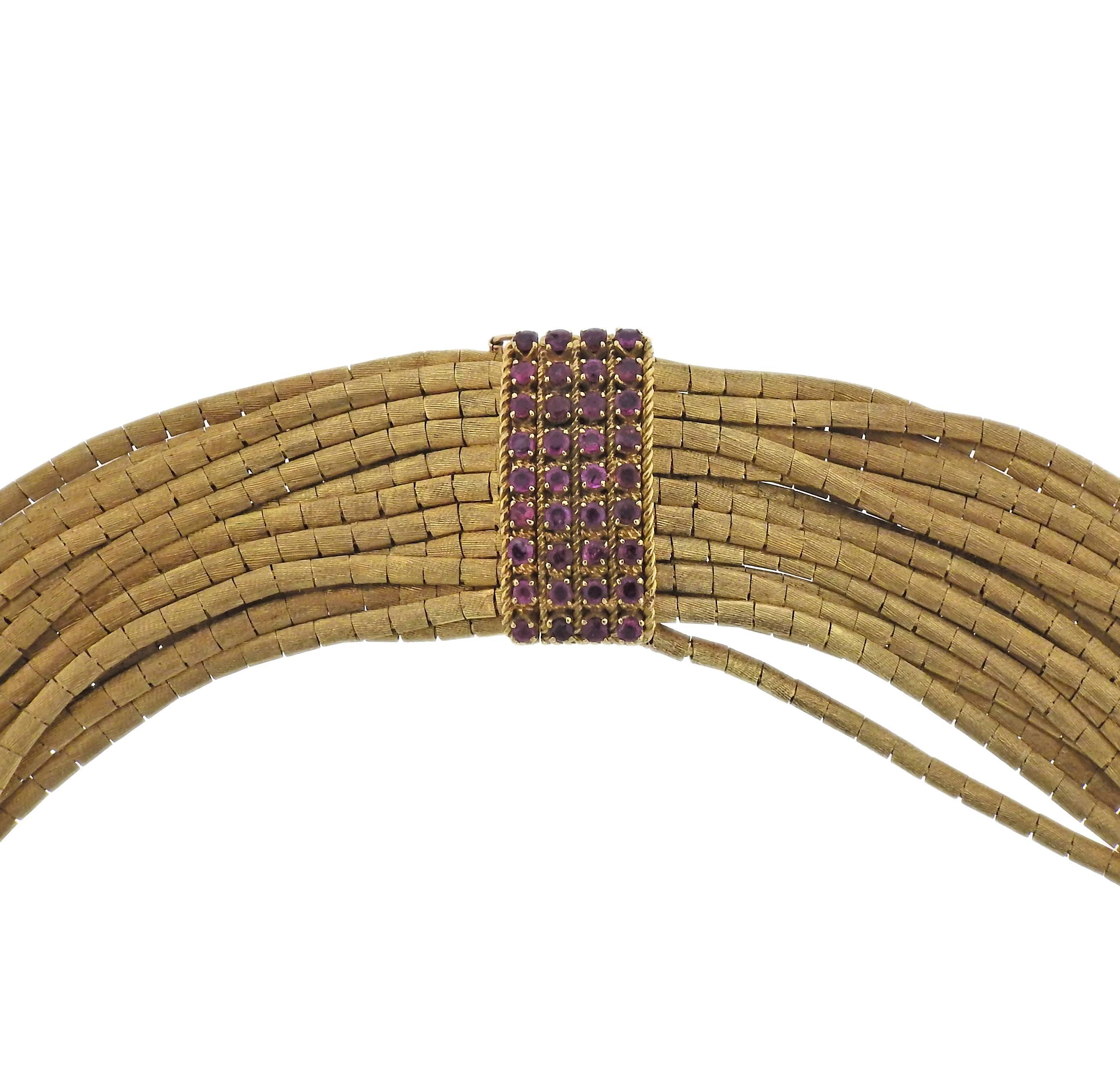 A 1960's 18k gold spaghetti necklace featuring rubies. Shortest strand measures 16" long necklace measures approx. 45mm wide and weighs 304.5 grams. Marked 750.