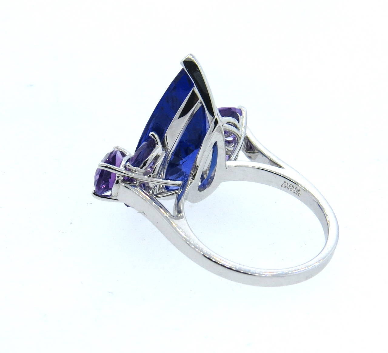 The luscious pear-shaped tanzanite with amethyst clusters shoulders to the delicate 18k white gold band. 
 
18k white gold ring by Chopard, set with a 9.32ct pear shape tanzanite and 2.09ctw amethysts on sides. Ring is a size 6 1/2, ring top is