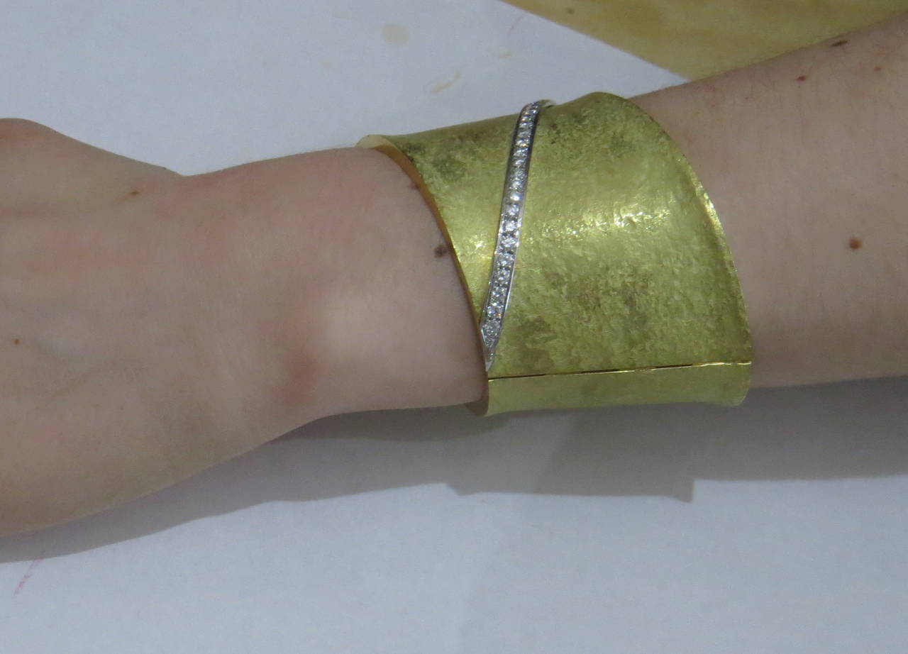 Substantial 18k textured finish gold cuff bracelet with hinged closure, featuring approximately 2.10ctw in G/VS diamonds. Bracelet will comfortably fit up to 7