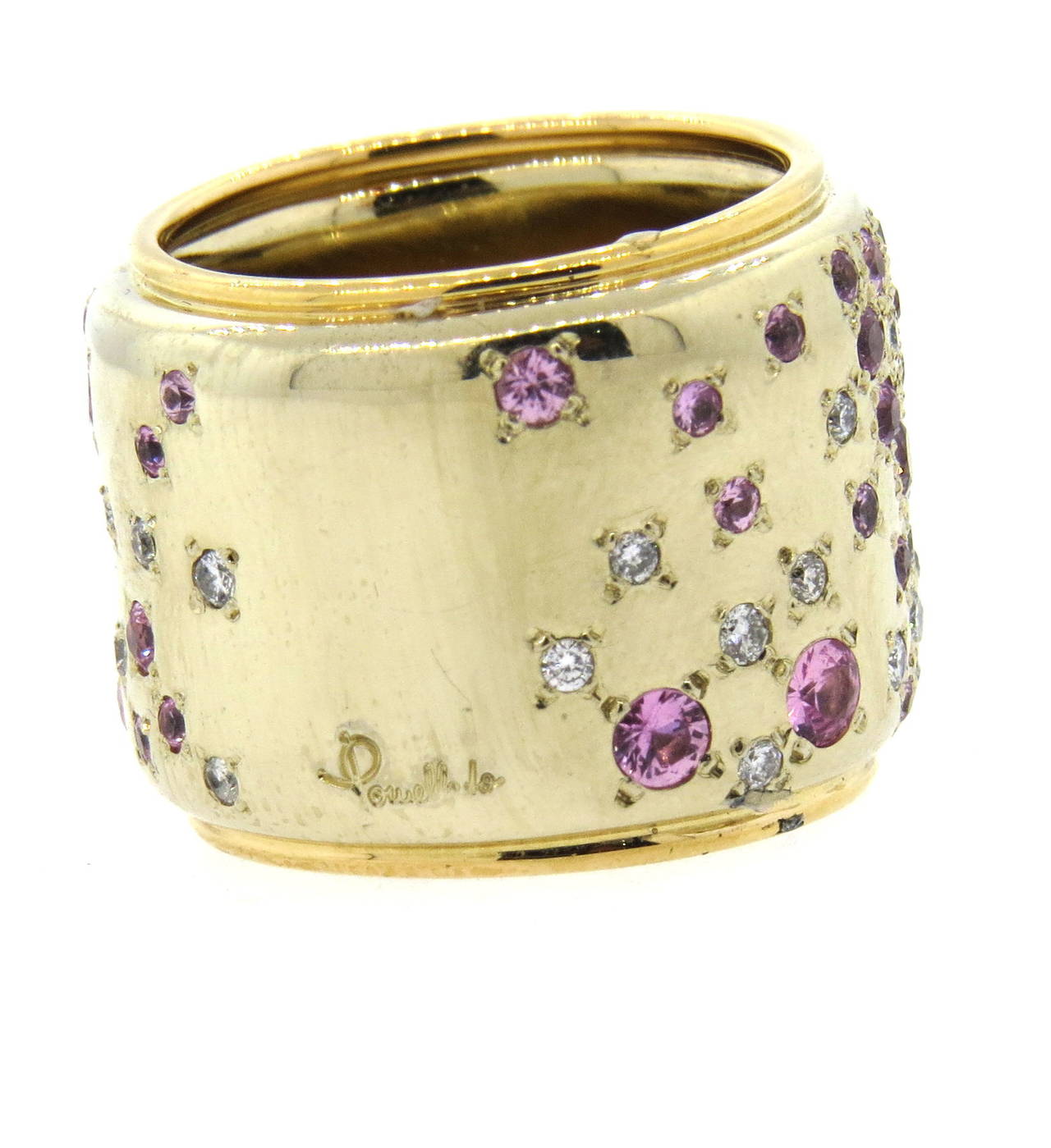 Large 18k gold wide band ring by Pomellato from Sabbia collection, adorned with approx. 0.60ctw in diamonds and pink sapphires. Ring is a size 6 3/4 and is 19mm wide. Marked 750, Pomellato and Italian gold mark. Weight of the piece - 33.9 grams