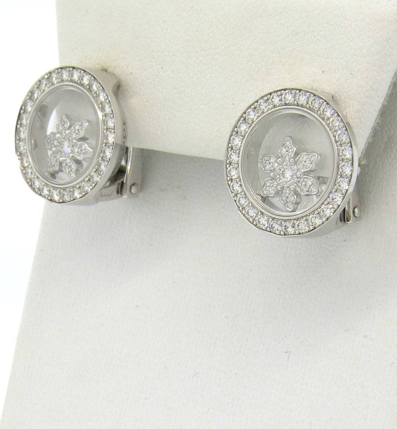 A pair of new Chopard 18k white gold earrings, featuring signature floating diamonds in the center in a form of snowflake. Earrings measure 17mm in diameter. Diamond total weight is approximately 1.00ctw including the snowflakes. Marked