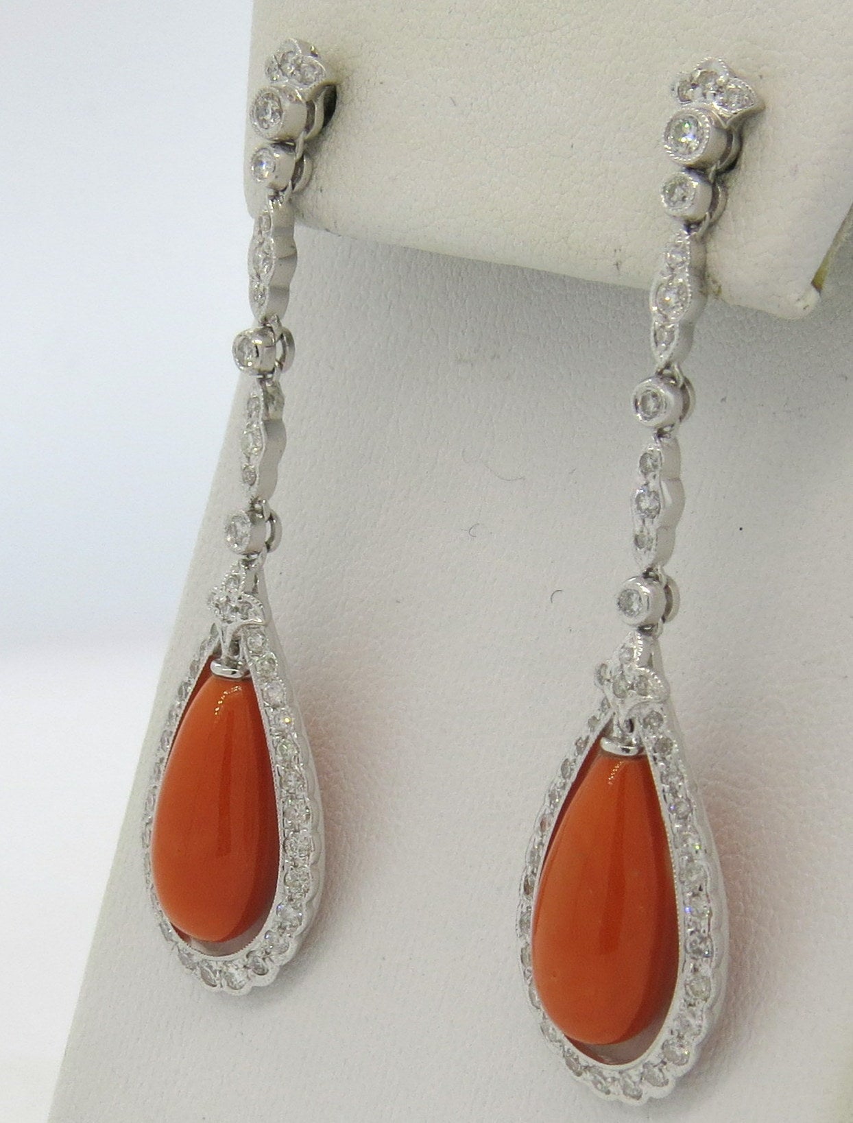 18k gold long drop earrings, featuring teardrop coral gemstones, adorned with approx. 1.20ctw diamonds. Earrings are55mm long x 15mm wide. Weight - 10.5 grams