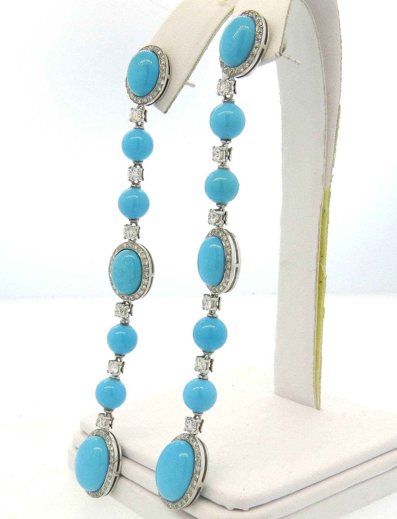 18k white gold long drop earrings, set with turquoise gemstones, decorated with approximately 1.80ctw in diamonds. Earrings are 86mm long and 11mm wide. Weight - 13.5 grams