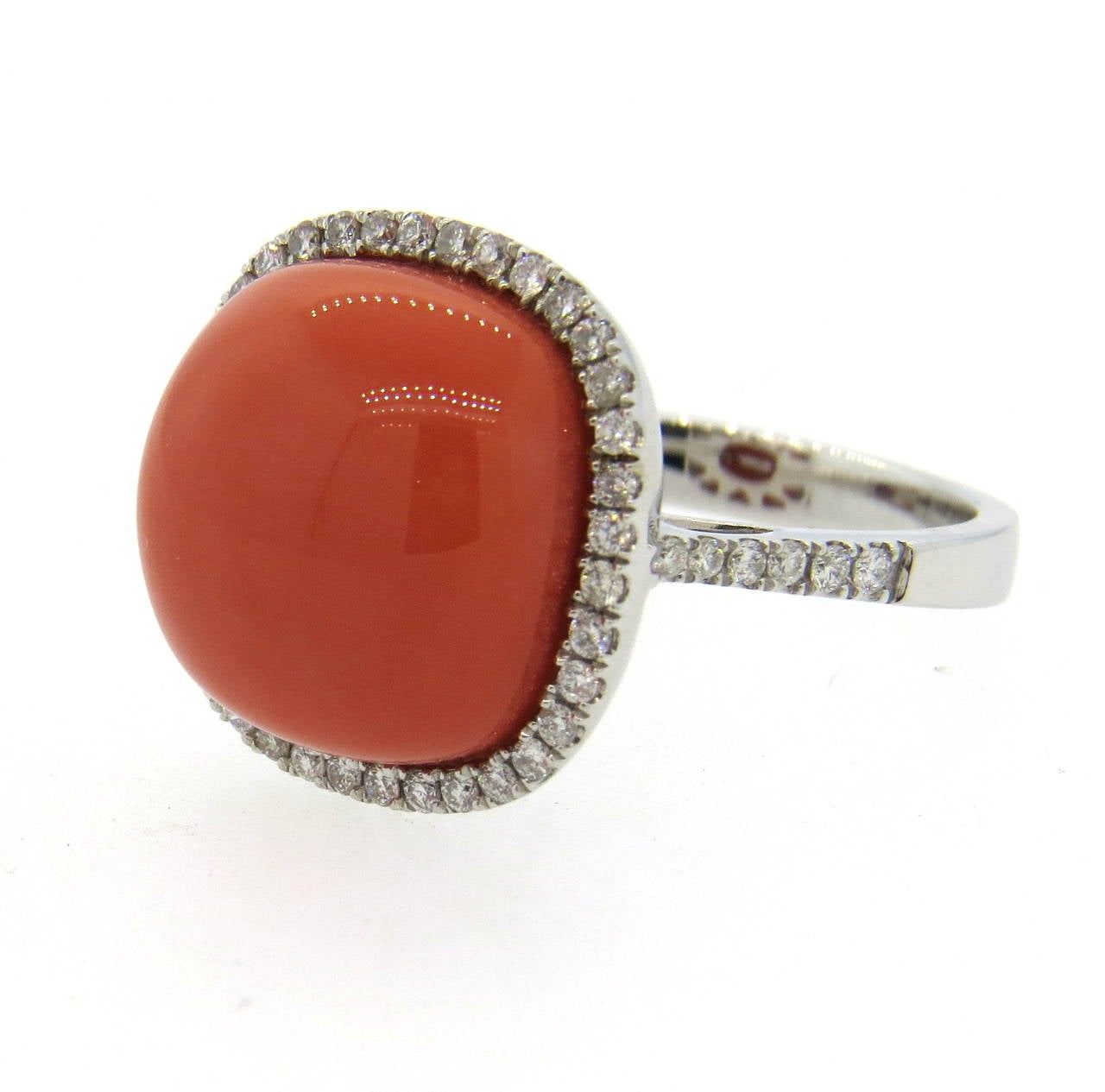 18k white gold ring, featuring coral  gemstones, surrounded with approximately 0.57ctw in diamonds. Ring is a size 7, ring top is 16mm x 16mm. Weight of the piece - 7.8 grams