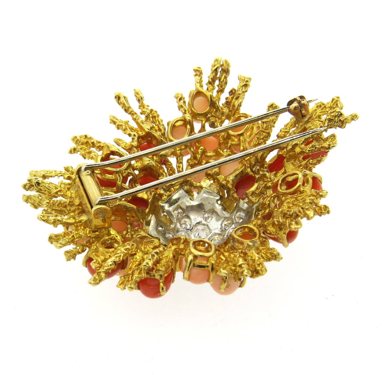 1970s 18k gold brooch, featuring red and angel skin coral cabochons, decorated with approximately 0.80ctw in diamonds in the center. Brooch measures 49mm x 50mm. Weight of the piece - 32.3 grams