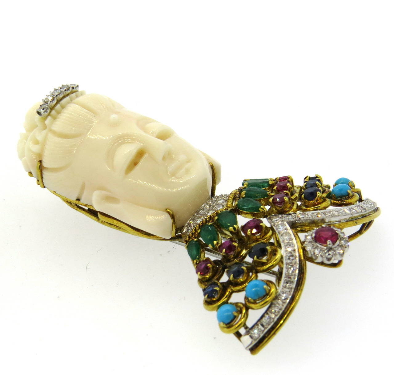 Impressive 18k gold brooch, featuring carved coral, decorated with diamonds, emeralds, sapphires, turquoise and rubies. Brooch measures 66mm x 41mm. Weight of the piece 41.2 grams