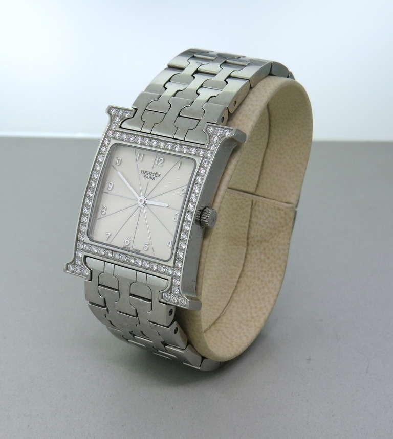 Hermes Lady's Stainless Steel and Diamond H Hour Large Size Wristwatch with Bracelet, Ref. HH1.530
Case Material: Stainless Steel and Diamonds
Case Dimensions: 30mm x 35mm
Movement: Quartz
Bracelet: Stainless Steel, Comfortably Fits Up To a