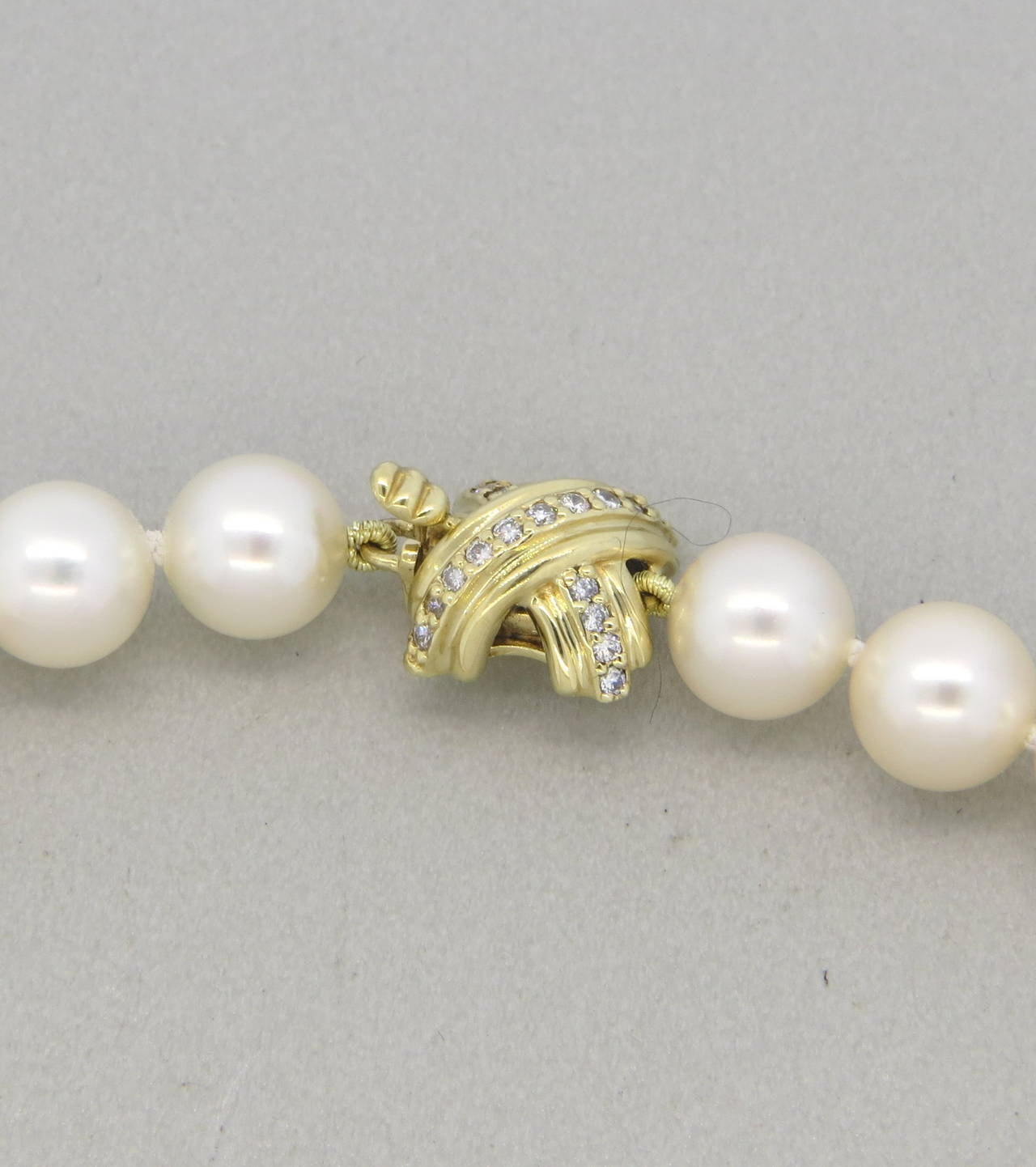 Tiffany & Co pearl necklace, featuring 18k gold and diamond classic X clasp. Pearls measure 8mm to 8.3mm in diameter. Clasp is 11mm x 11mm. Necklace is 17 1/2