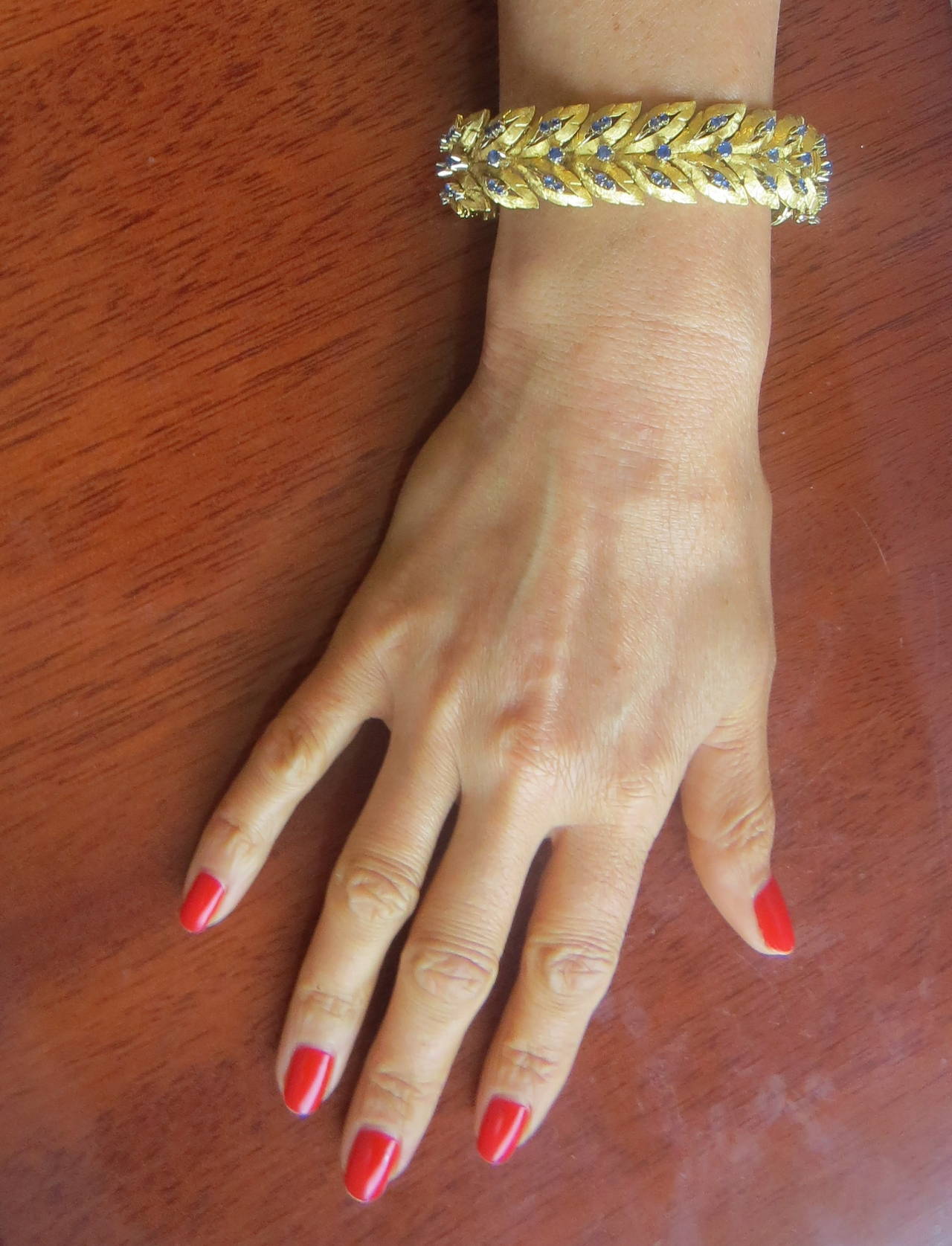 Vintage 18k gold leaf motif bracelet, decorated with blue sapphire gemstones. Bracelet is 7 1/8