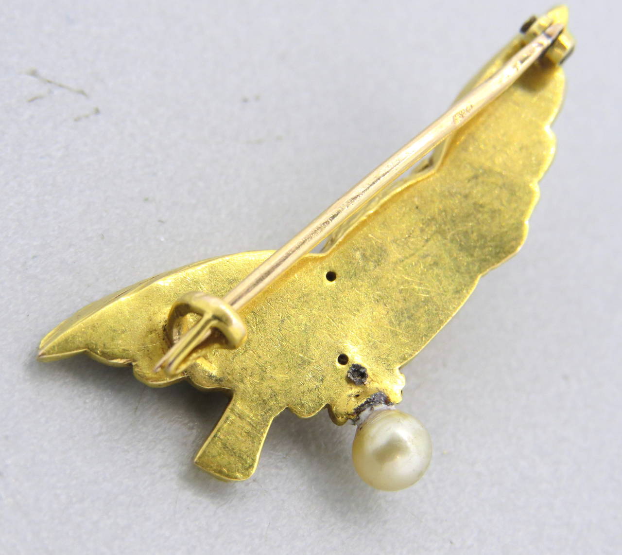 Antique 18k gold brooch, featuring an owl, decorated with one 4.5mm pearl, emeralds and diamonds. Brooch measures 40mm x 19m. Weight of the piece - 8.6 grams