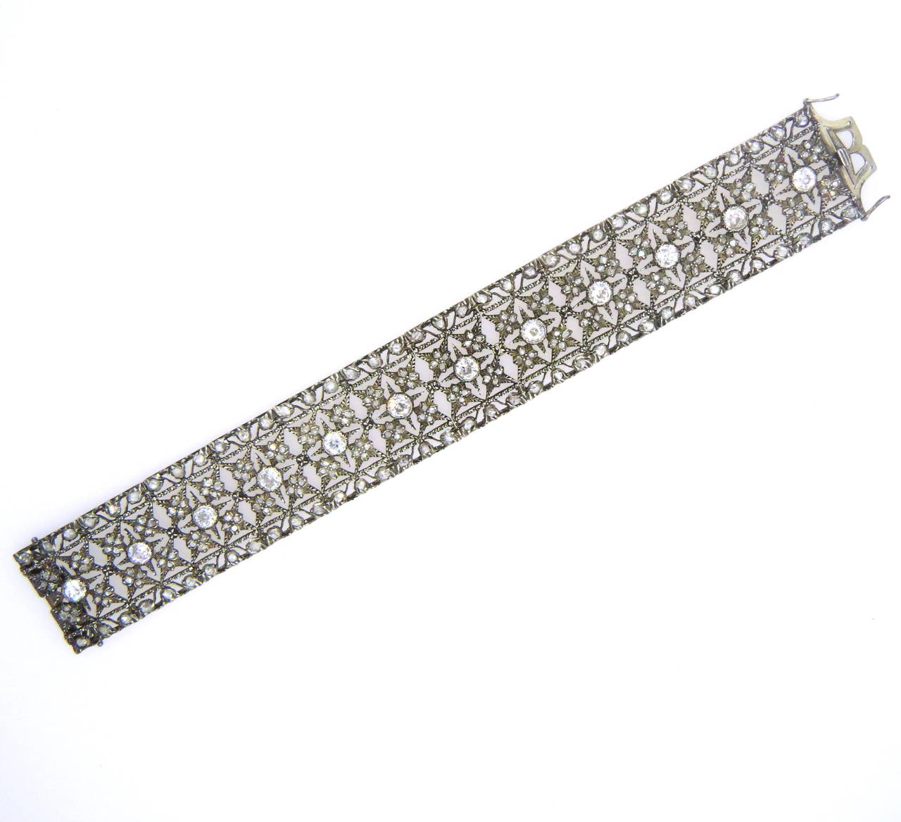 An 18k gold and silver bracelet set with approximately 5 carats of old mine cut diamonds and an additional 7 carats of rose cut diamonds.  Crafted by Mario Buccellati, the bracelet measures 7 1/4