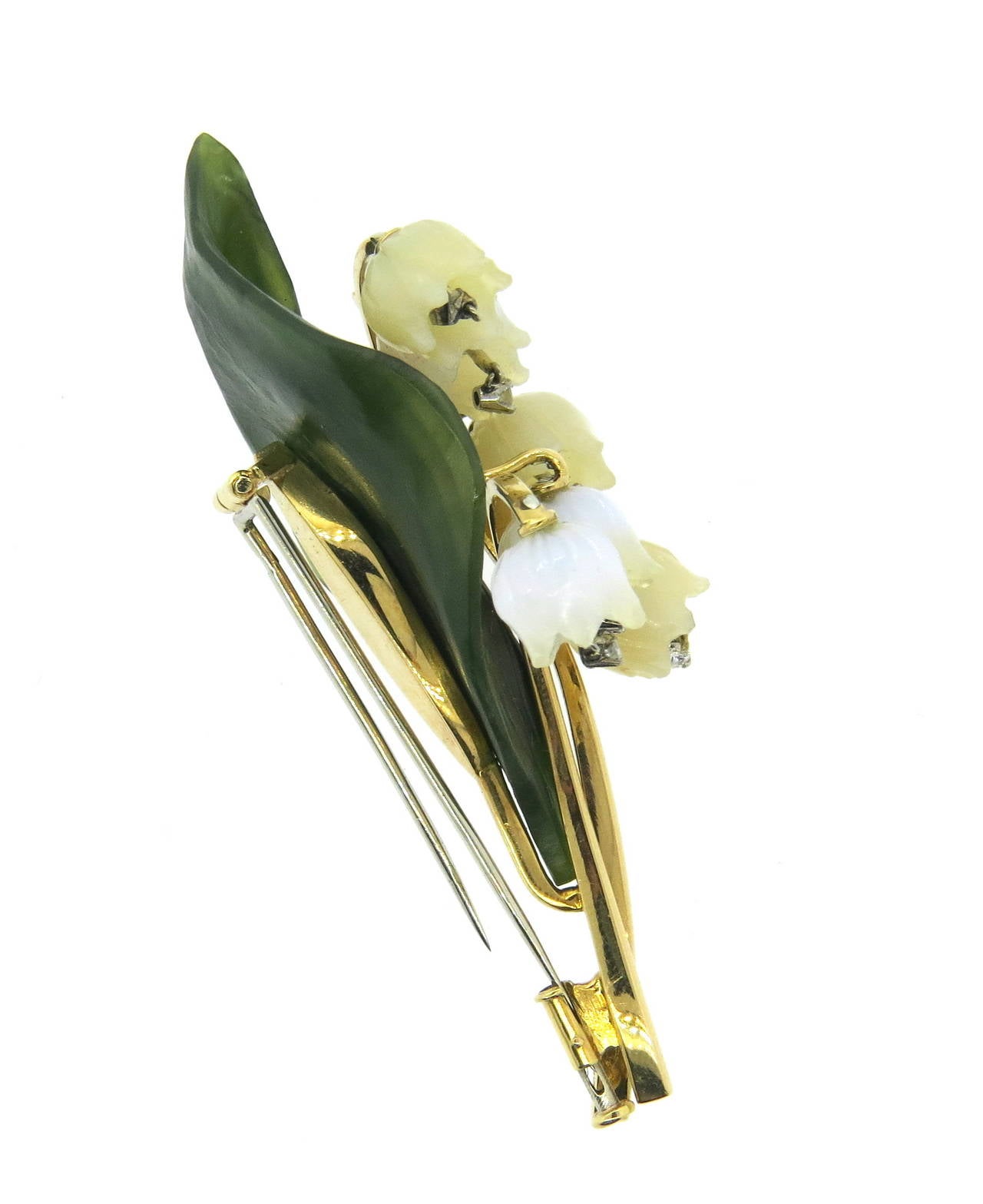 Beautiful and delicate brooch, set in 18k gold, featuring carved nephrite leaf and mother of pearl lily of the valley flowers,each decorated with dangling diamond. Brooch measures 65mm x 30mm. Weight of the piece - 19.2 grams