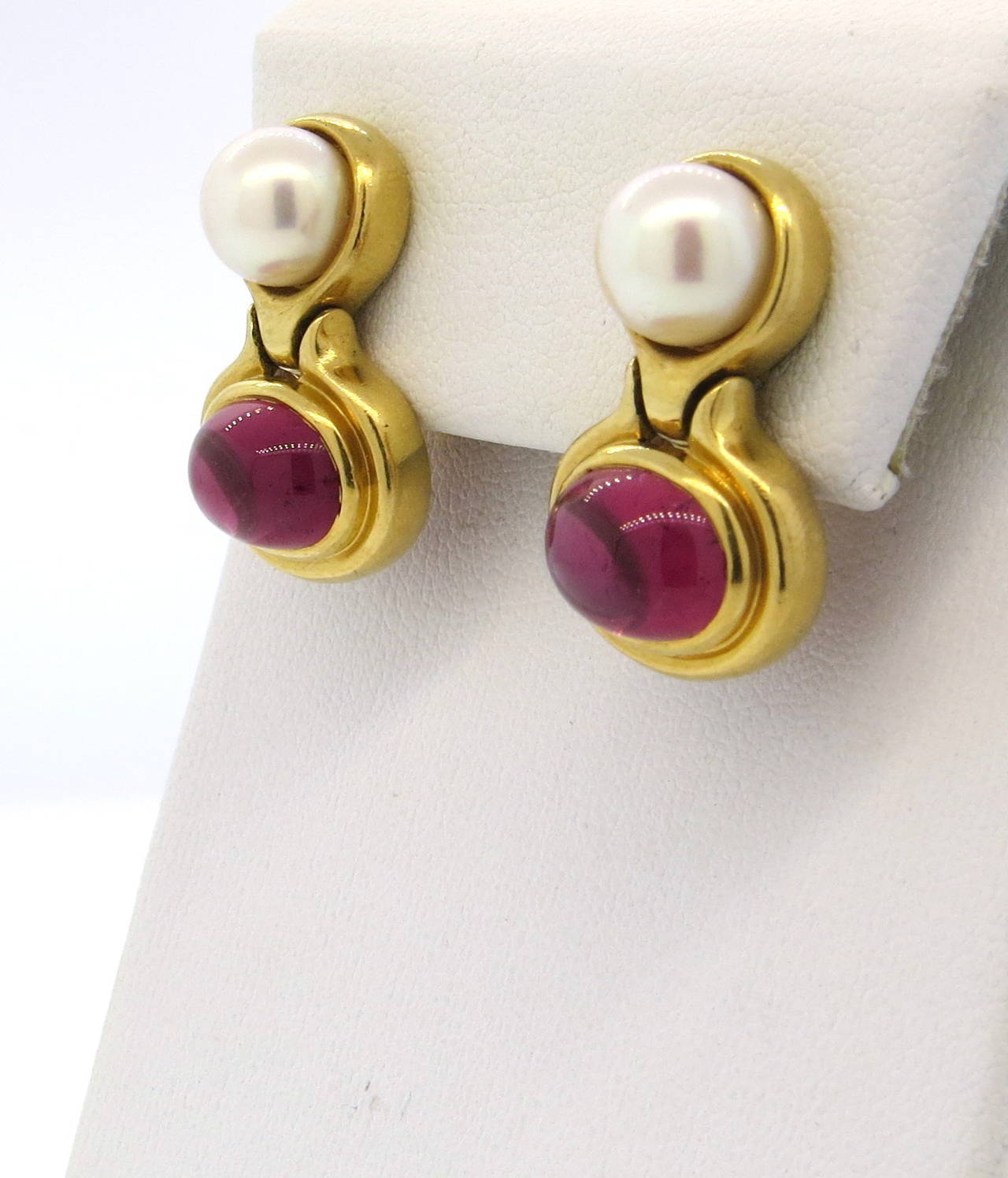 A pair of 18k yellow gold earrings set with pink tourmaline cabochons 10.4mm x 8mm and saltwater cultured pearls 8.5mm in diameter.  Crafted by Bulgari, the earrings measure 25mm x 16mm and weigh 21 grams.  Marked Bulgari, 750, Italian Assay Marks.
