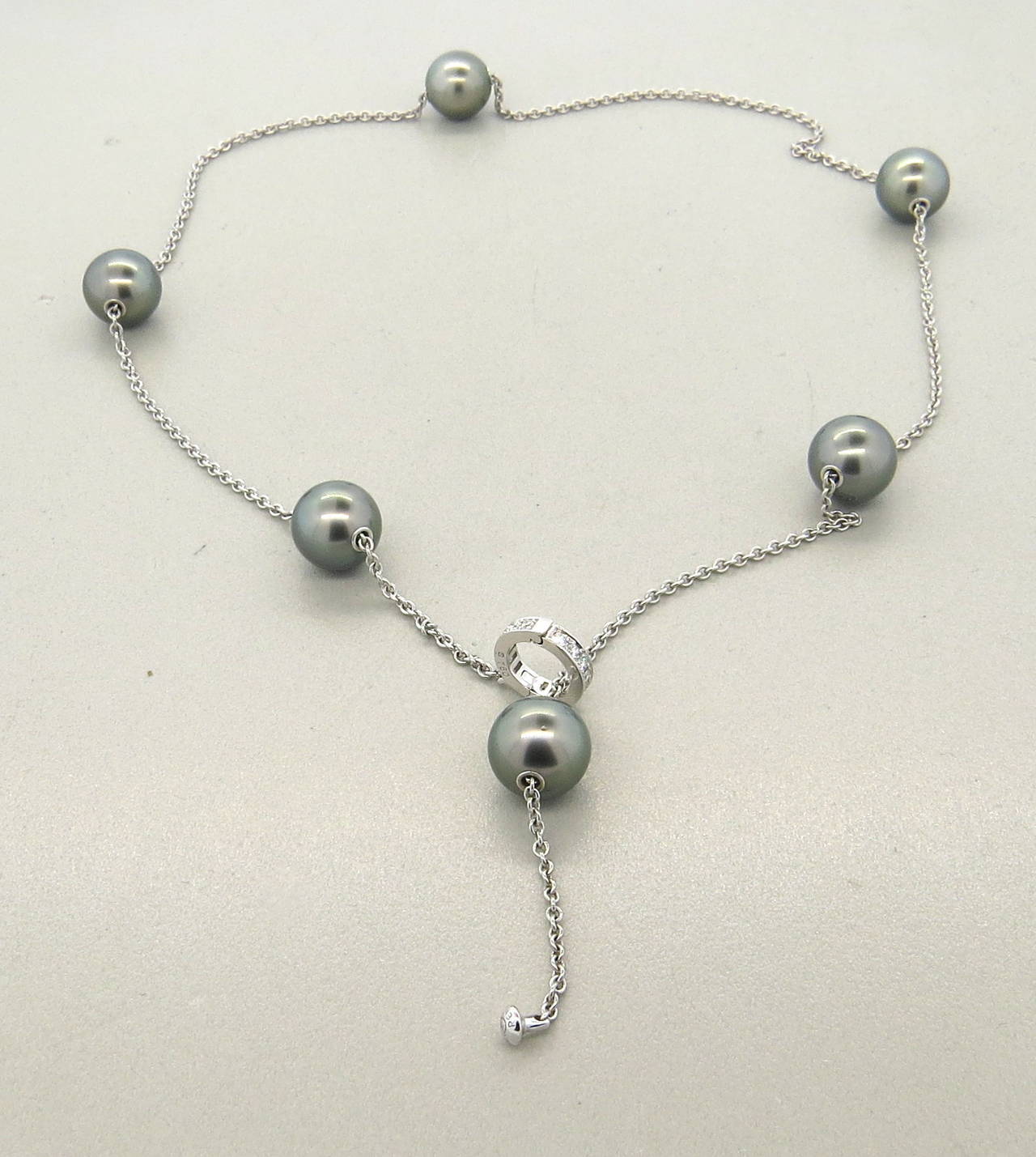 An 18k white gold necklace adorned with six movable Tahitian pearls 10mm - 10.6mm in diameter and approximately 0.20ctw of G/VS diamonds.  The diamond station opens and the pearls move along the chain so the piece can be worn at many lengths.  The