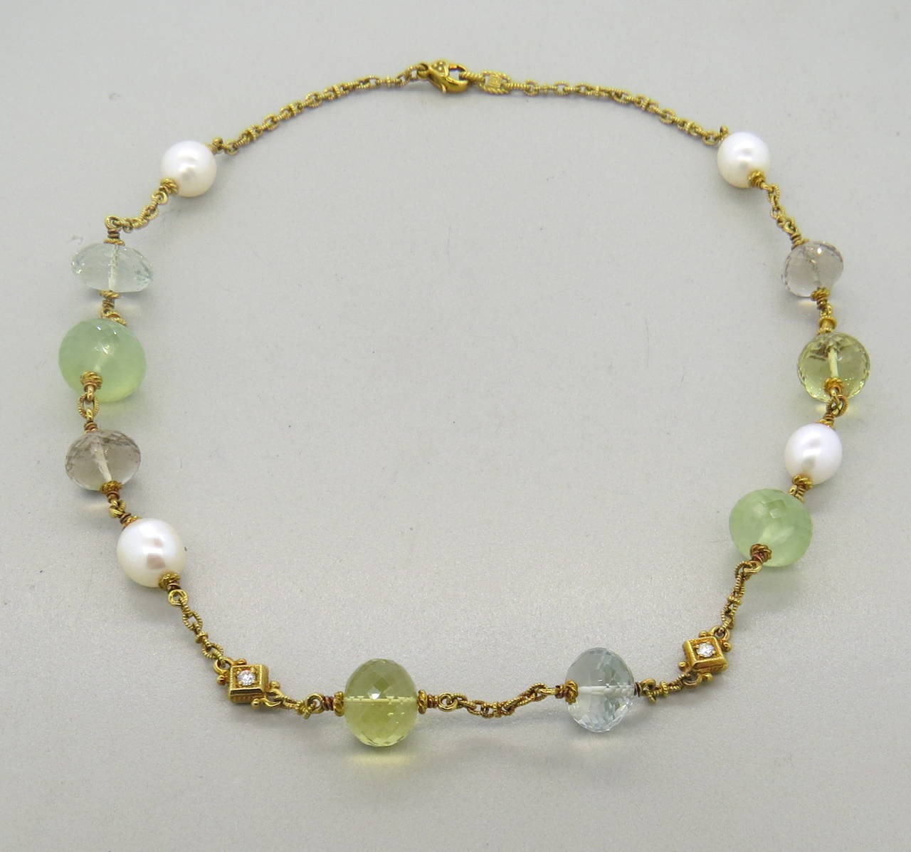 An 18k yellow gold necklace set with pearls 10.4mm x 9.8mm and multicolor quartz stations approximately 13mm in diameter.  Crafted by Judith Ripka, the necklace measures 18