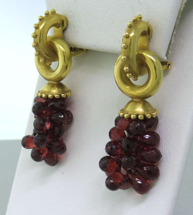 Metal: 18k Yellow Gold
Gemstone: Garnet
Dimensions: 49mm x 14mm
Weight: 27.2g

Earrings Have Collapsible Posts (can be worn as clips or pierced)