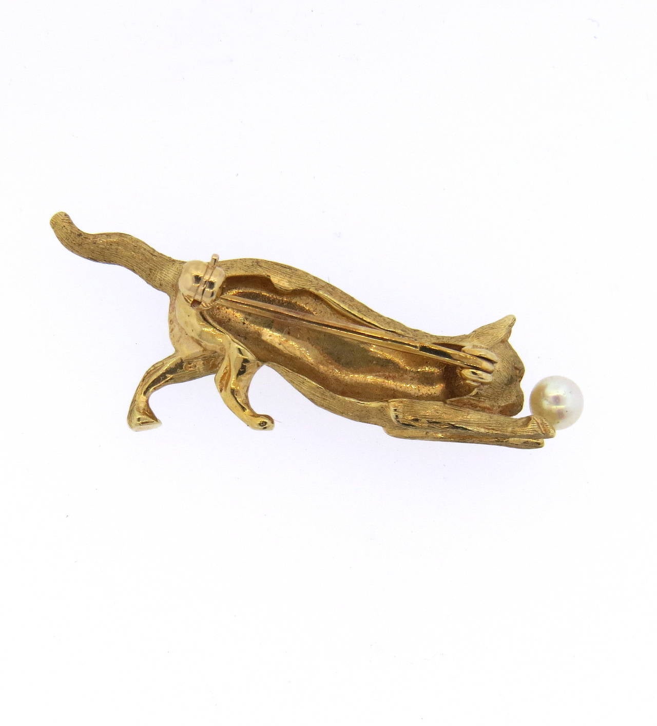 Whimsical vintage brooch, crafted in 14k brushed finish gold, featuring playing cat with a 3.9mm pearl. Piece measures 40mm x 15mm and weights 7.7 grams