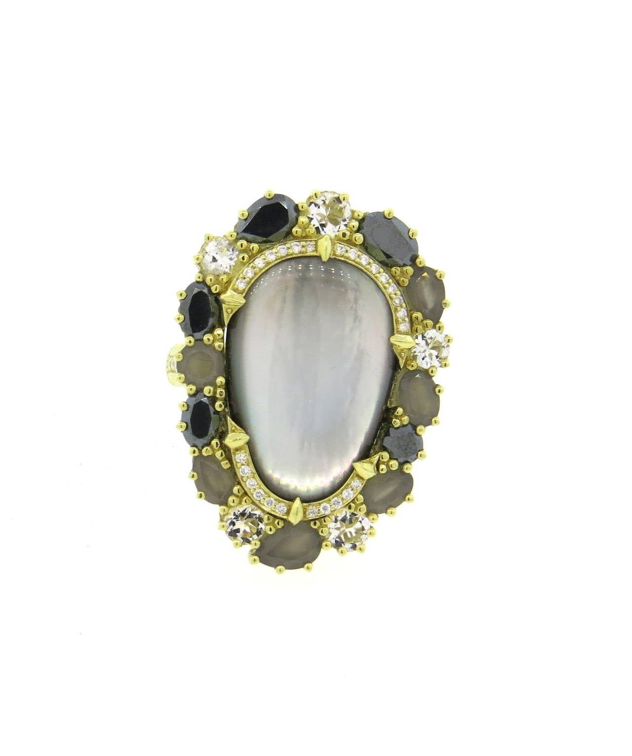An 18k yellow gold ring set with a mother of pearl and quartz doublet, surrounded by black diamonds, quartz and gray moonstone.  The ring is also set with approximately 0.15ctw of G/VS diamonds.  Crafted by Judith Ripka, the ring is a size 7.  The