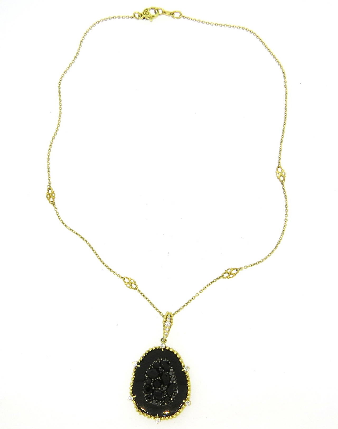 An 18k yellow gold necklace featuring a pendant set with approximately 0.22ctw of G/VS diamonds, onyx and black diamonds.  Crafted by Judith Ripka, the necklace is 16.5