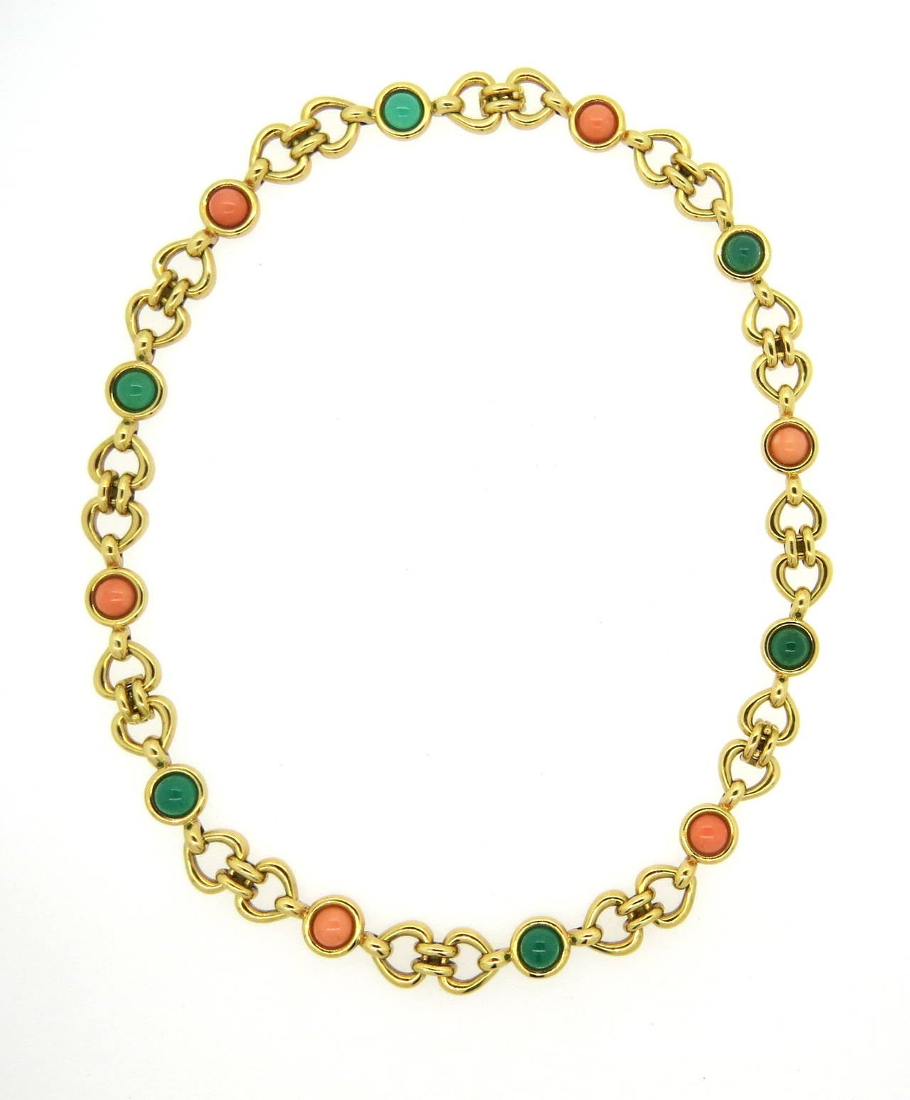 An 18k yellow gold necklace which converts into three bracelets.  The piece is set with coral and chrysoprase cabochons 8.5mm - 8.6mm in diameter.  Each bracelet measures 6.75