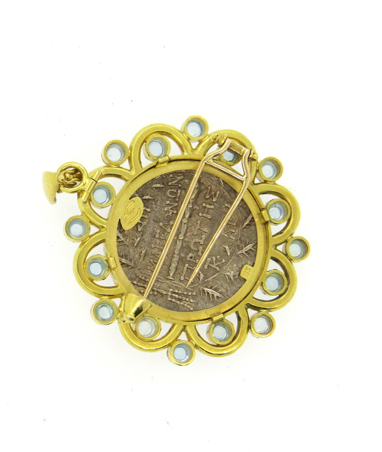 An 18k yellow gold brooch that can also be worn as a pendant.  The piece is comprised of numerous moonstone cabochons approx. 4mm in diameter which surround a coin 29mm in diameter.  Crafted by Elizabeth Locke, the piece measures 48mm x 48mm
