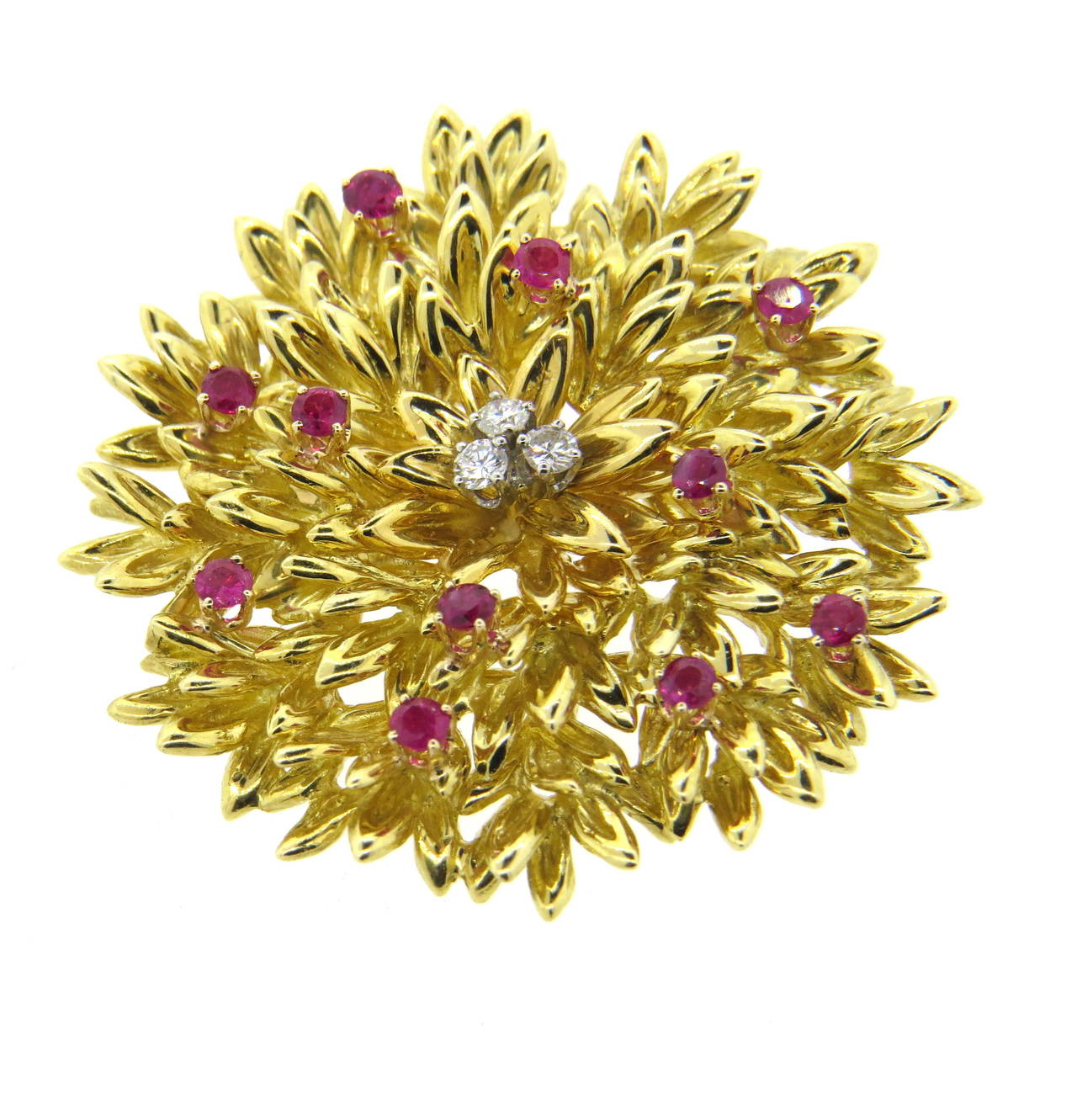 An 18k yellow gold pin set with rubies and approximately 0.15ctw of G/VS diamonds.  Crafted by Tiffany & Co., the pin measures 41mm in diameter and weighs 25 grams.