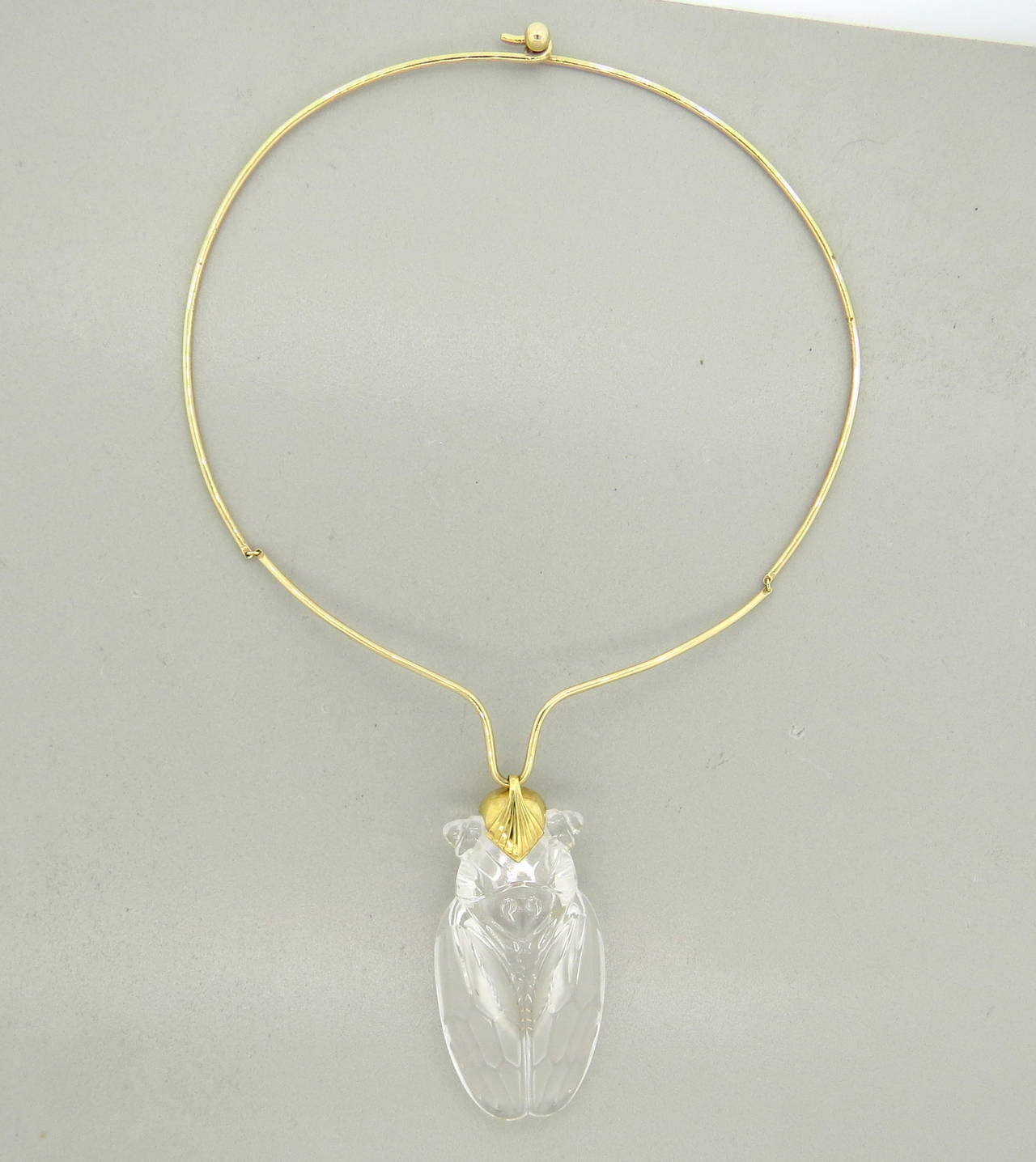 A 14k yellow gold necklace adorned with a crystal pendant depicting a cicada.  Crafted by Steuben, the necklace is 14.5