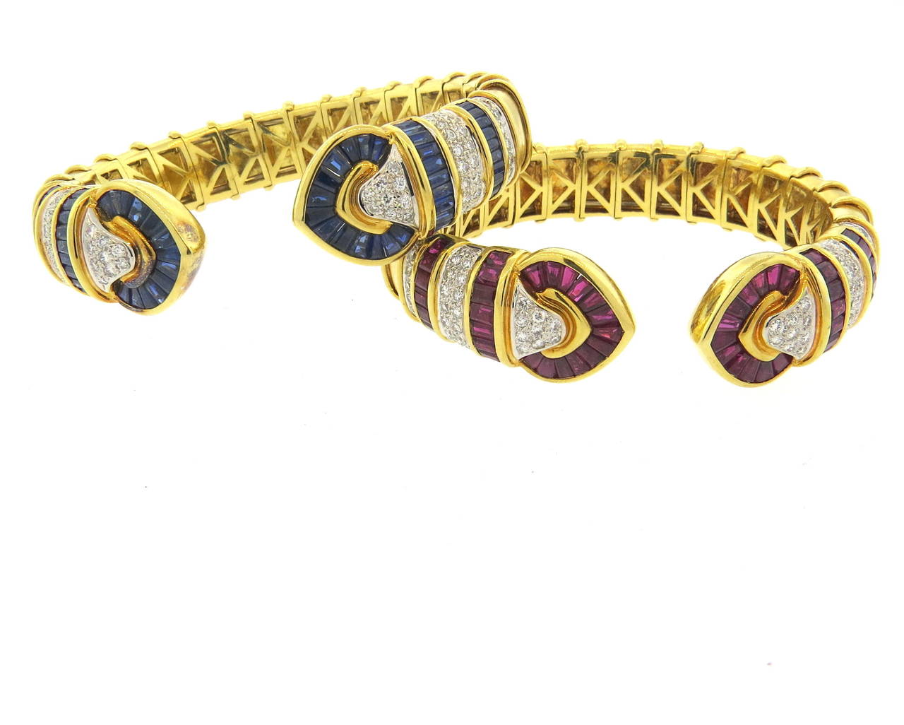 Set of two fine 18k gold cuffs, set with approx. 1 carat in diamonds each, and a total of 7 - 7.5ctw in both rubies and sapphires. Bracelets will fit up to 6 1/2