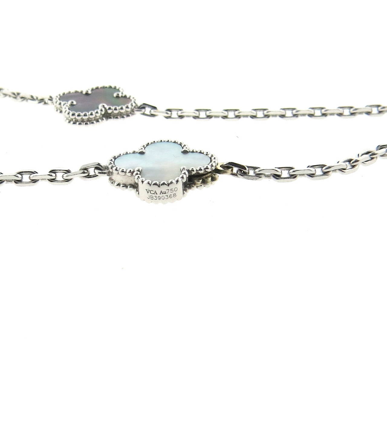 18k white gold long necklace, crafted by Van Cleef  & Arpels from iconic Magic Alhambra collection, set with black, gray and white mother of pearl lovers, measuring from 15mm x 15mm to 25mm x 25mm. Necklace is 49