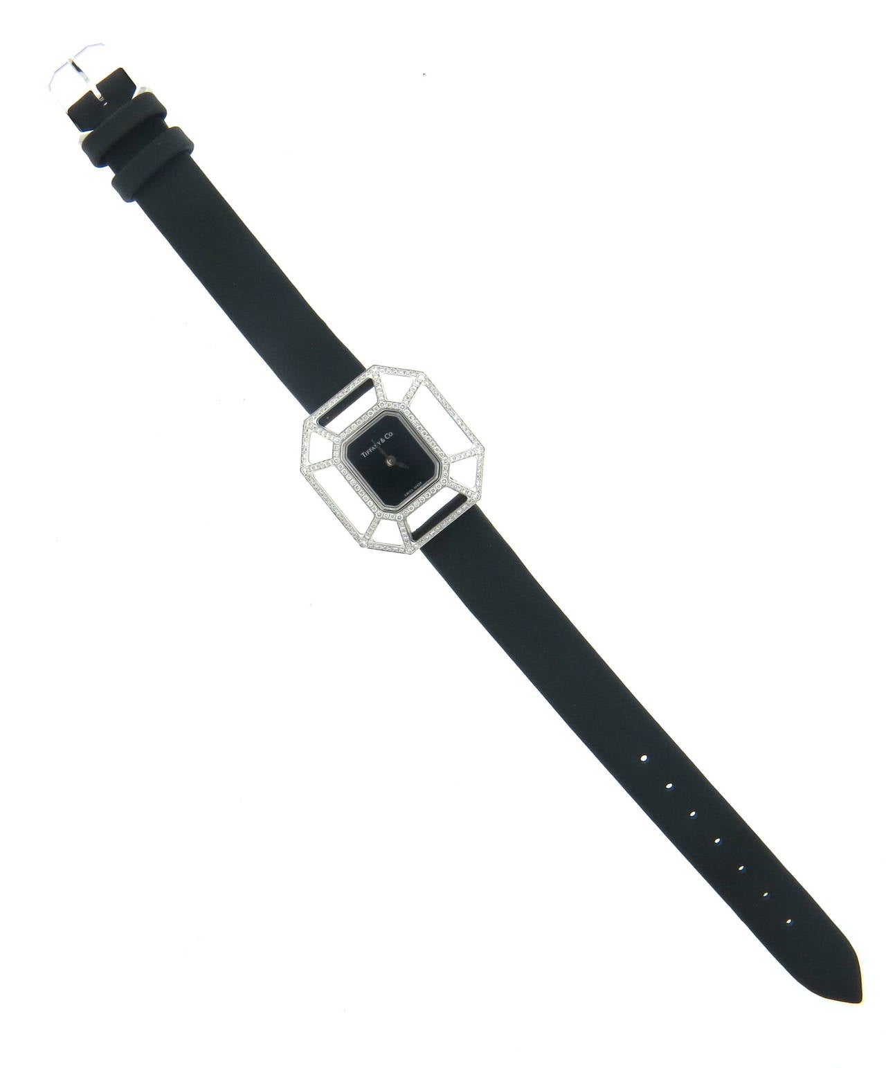 18k white gold watch, designed by Paloma Picasso for Tiffany & Co, open pyzzle case is decorated with approx. 0.57ctw in diamonds, measuring 25mmx  27mm, featuring black dial, signed Tiffany & Co. Quartz movement. Black satin leather band is 7 1/8
