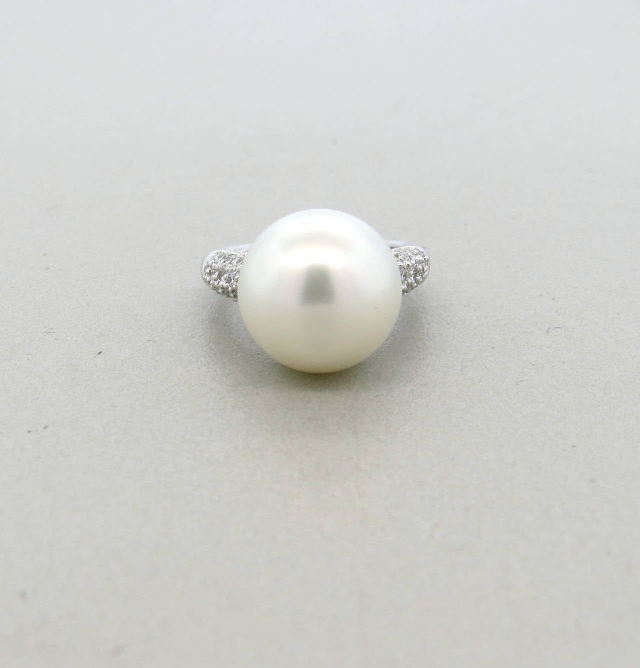 Platinum cocktail ring featuring a 12.7mm South Sea pearl decorated with approximately 0.60ctw of diamonds. Ring size 4.25. Marked Plat, 060. Ring weighs 9.1 grams.