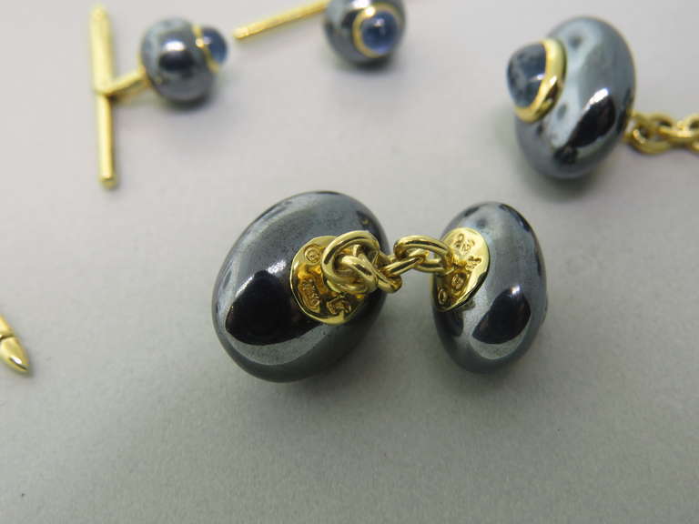 18k gold stud and cufflink set by Trianon with hematite and sapphire cabochons. Cufflink tops are 15.7mm x 11.8mm and 13.8mm x 9.5mm, stud top is 8mm in diameter.Marked Trianon,750. weight - 23.8g