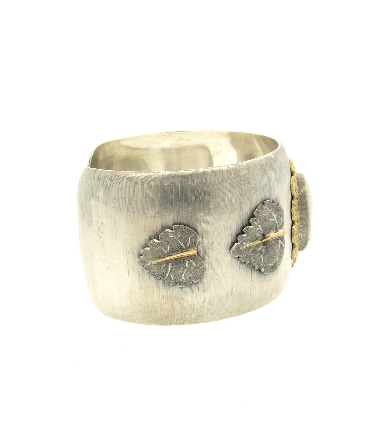 A sterling silver and 18k yellow gold cuff bracelet, set with a mabe pearl 18.1mm x 13.2mm in the center and leaf accents on the sides.  Crafted by Mario Buccellati, the cuff is 37mm wide and comfortably fits up to a 6.25