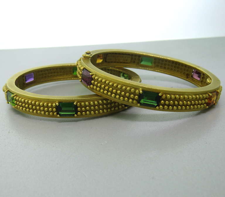 Set of two 18k gold stackable bracelets by Barry Kieselstein-Cord, featuring multicolor semi precious gemstones: tourmalines, amethyst, citrine, peridot, topaz. Each bracelet will fit an average size wrist, up to 7