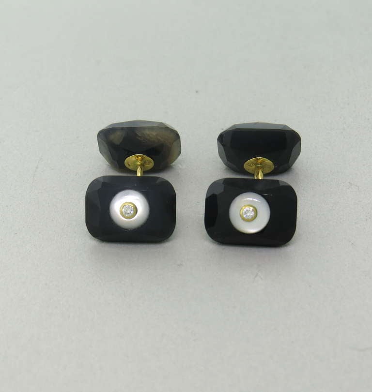 18k gold cufflinks featuring a faceted black stone with mother of pearl and approximately 0.12ctw in diamonds.  Cufflinks measure 15mm x 11mm and weigh 10.4 grams.