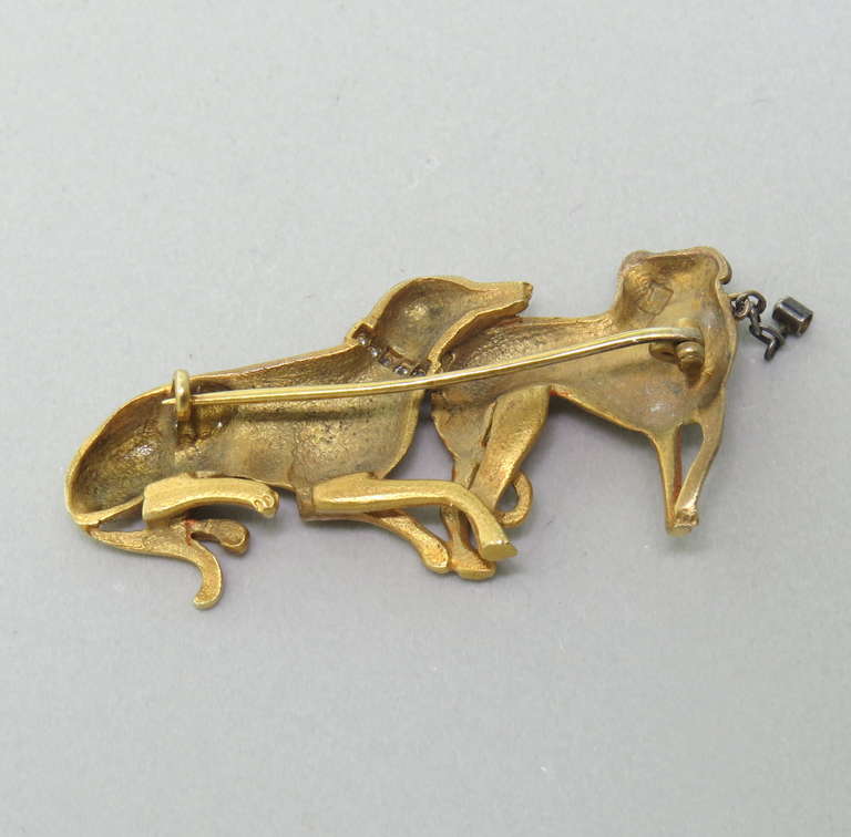 This rare antique brooch is in pristine condition, featuring two greyhounds in a resting position, adorned with diamonds.  The 14k gold piece measures 45mm x 22mm and weighs 8.1grams.