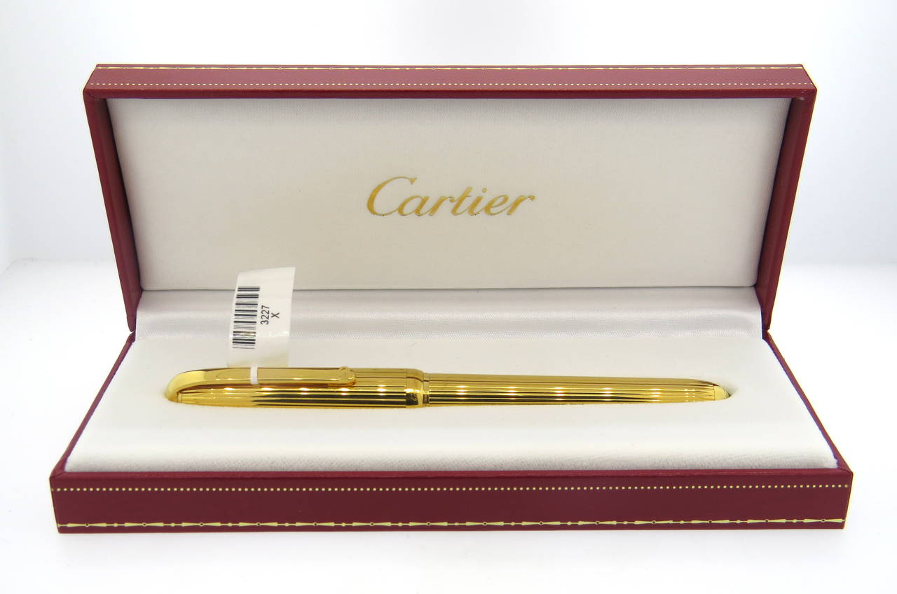 Cartier Paris gold plated fountain pen from the Gordon Vertical collection. Reference No. ST170005. 18K gold medium nib. Pen measures 145mm end to end. Bottom of pen features onyx. Pen is marked Cartier Paris, Made in France, Plaque OR G. Serial No.