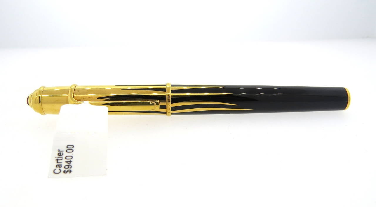 Lovely Cartier Mini Diabolo black lacquer fountain pen featuring gold finishes and an 18K gold nib. Pen measures 120mm long and has a jeweler's ruby on cap. Pen is a brand new in store sample and comes with booklets and cartridges. Pen is marked
