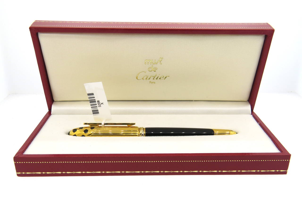 Cartier black lacquer and gold trim fountain pen from the Panthere collection featuring an 18K gold nib and an onyx stone on the cap and end. Pen is a brand new, store sample, comes with original box, booklets and 10 cartridges. Pen measures 130mm