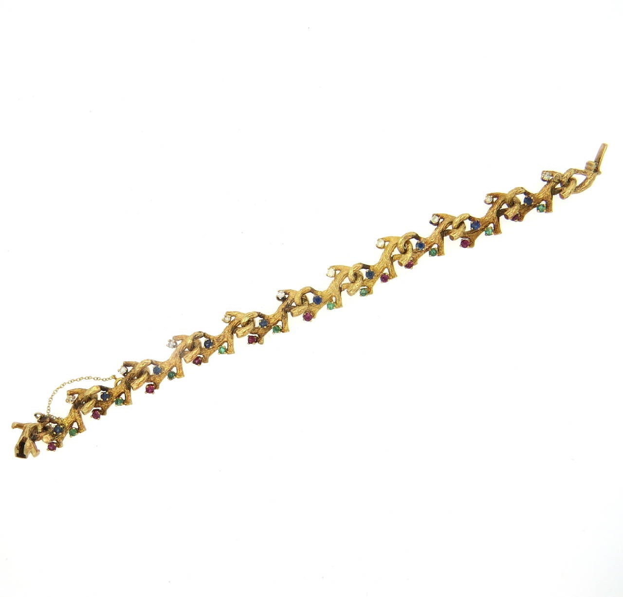 An 14k gold bracelet set with rubies sapphires emeralds and approximately 0.50ctw of G/VS diamonds.  The bracelet is 7.5