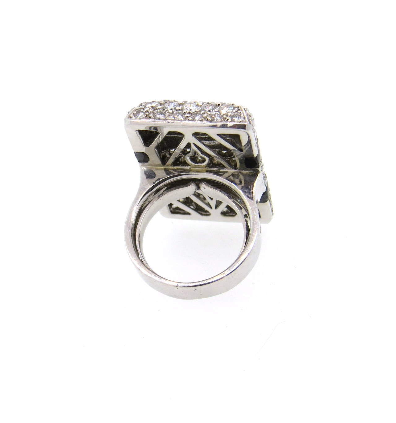 An 18k white gold cocktail ring set with approximately 5.50ctw of G/VS diamonds and onyx.  The ring is a size 5.5 and the top of the ring measures 30mm x 19mm.  The weight of the piece is 20.8 grams