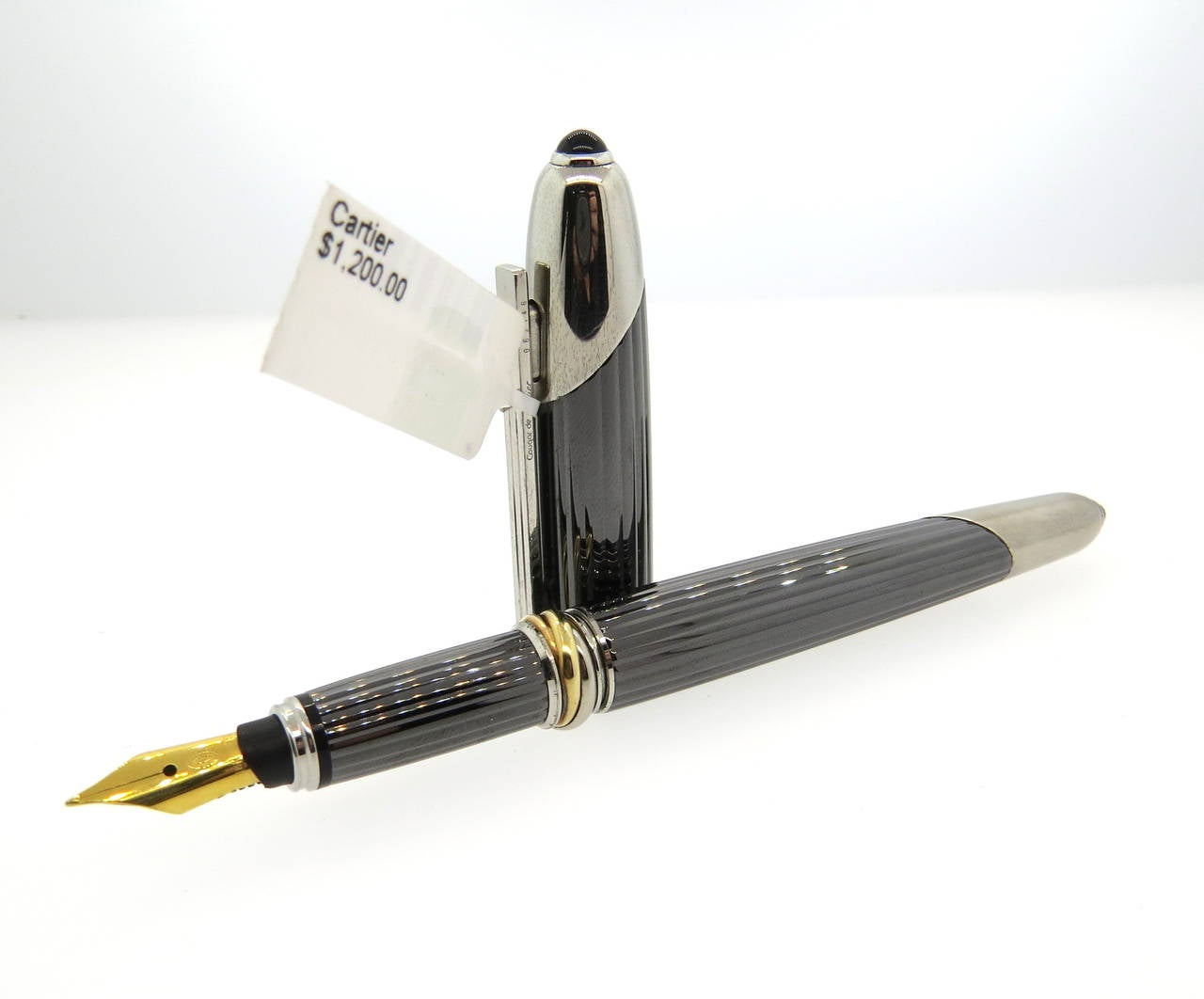 Cartier fountain pen featuring a titanium fluted body with platinum plated accents and an onyx cabochon on the cap and bottom.  The titanium body Is dark, representing a cougar. Overall Design Is Simple Yet Elegant.Cartier's Signature Tri-Color