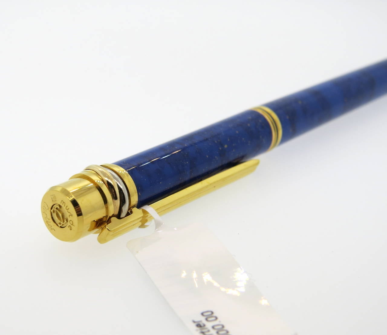 Cartier Must de Cartier lapis lazzuli lacquer fountain pen with classic trinity rings around pen cap. Pen features an 18K gold nib and gold plated finishes. Pen measures 140mm long. Pen is a brand new in store sample, comes with original box, papers