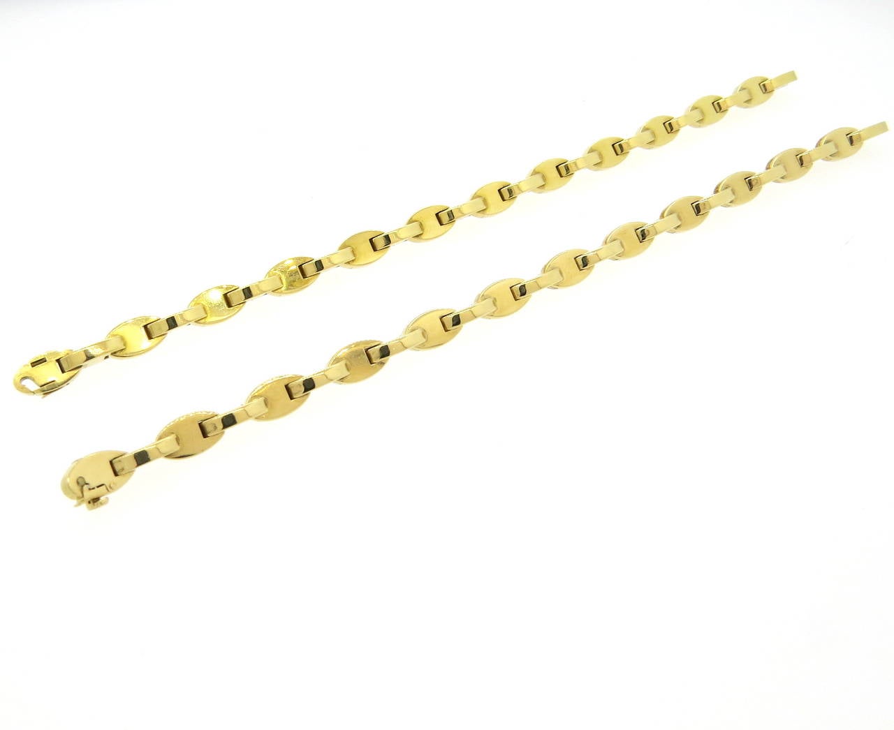 A pair of 18k yellow gold bracelets.  Crafted by Hermes, the bracelets each measure 7